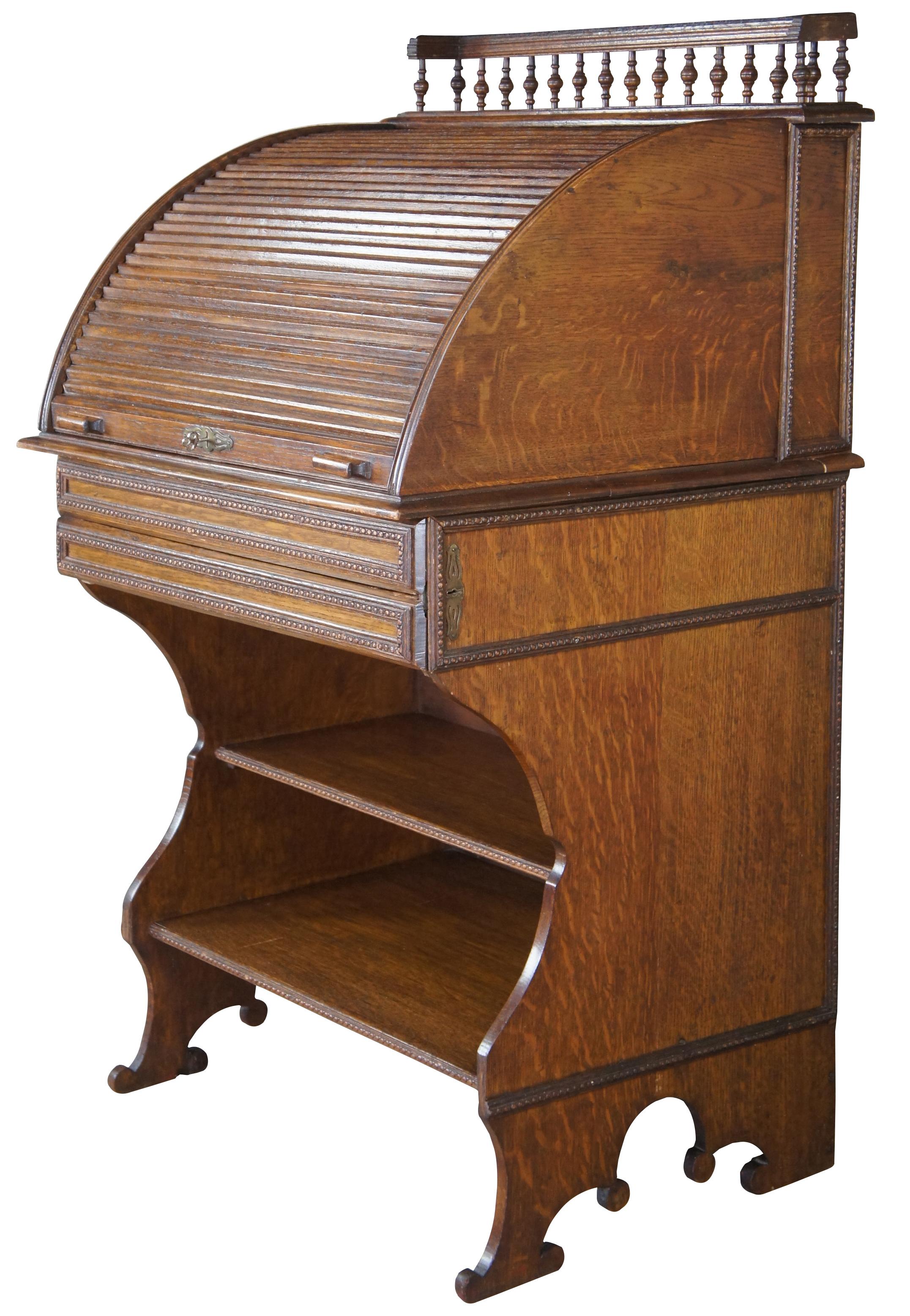 Rare antique Victorian roll top library writing desk. Made of quartersawn oak featuring a tambour door that opens to multiple cubbies / compartments and file / letter storage with two inkwells and pen holder. Also features an upper gallery with