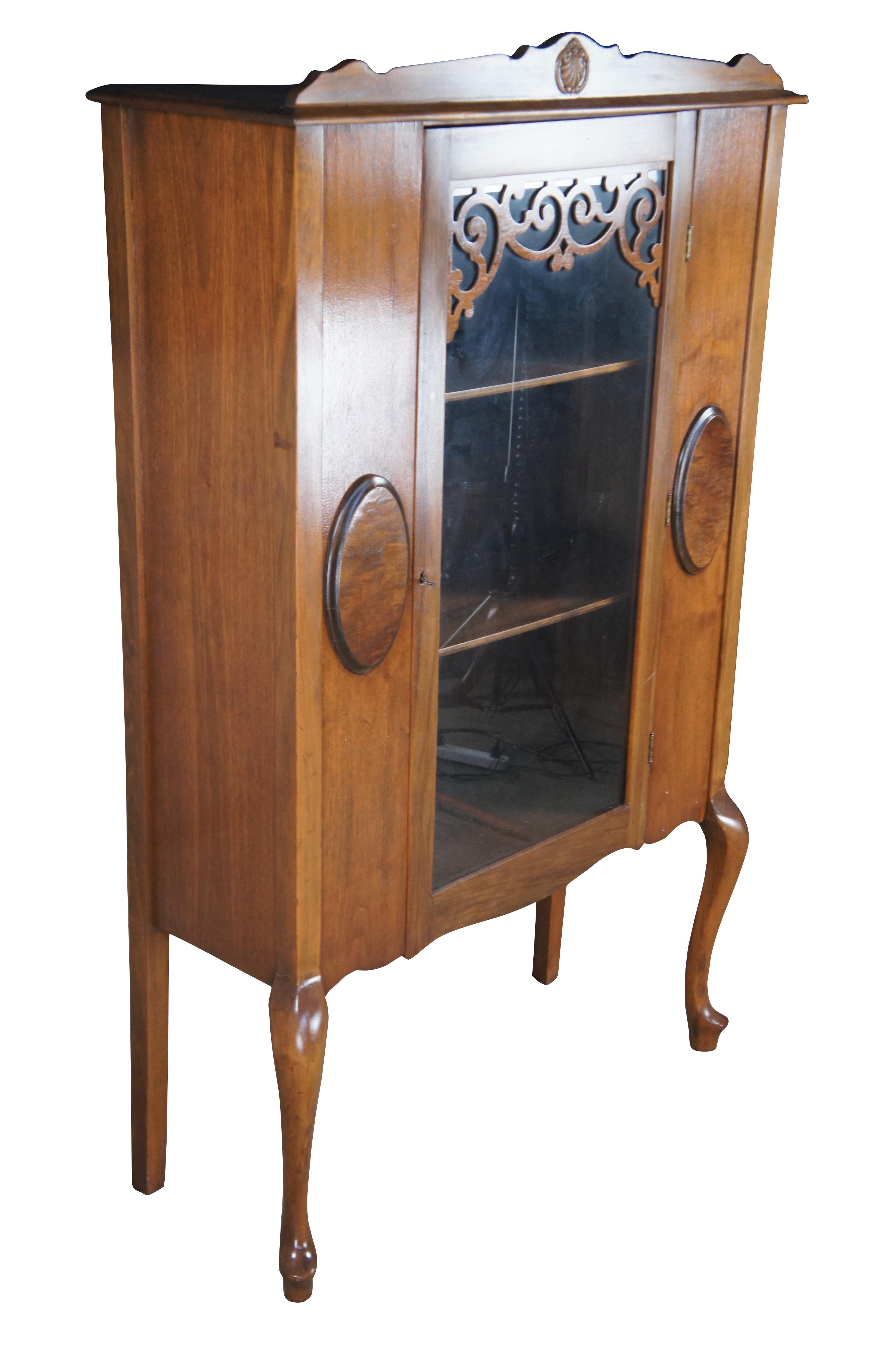 Antique Victorian china display hutch / bookcase / cupboard.  Made of walnut featuring Queen Anne styling with shell design crown, serpentine fretwork door, oval panels. and cabriole legs with slipper feet.

Dimensions:
38