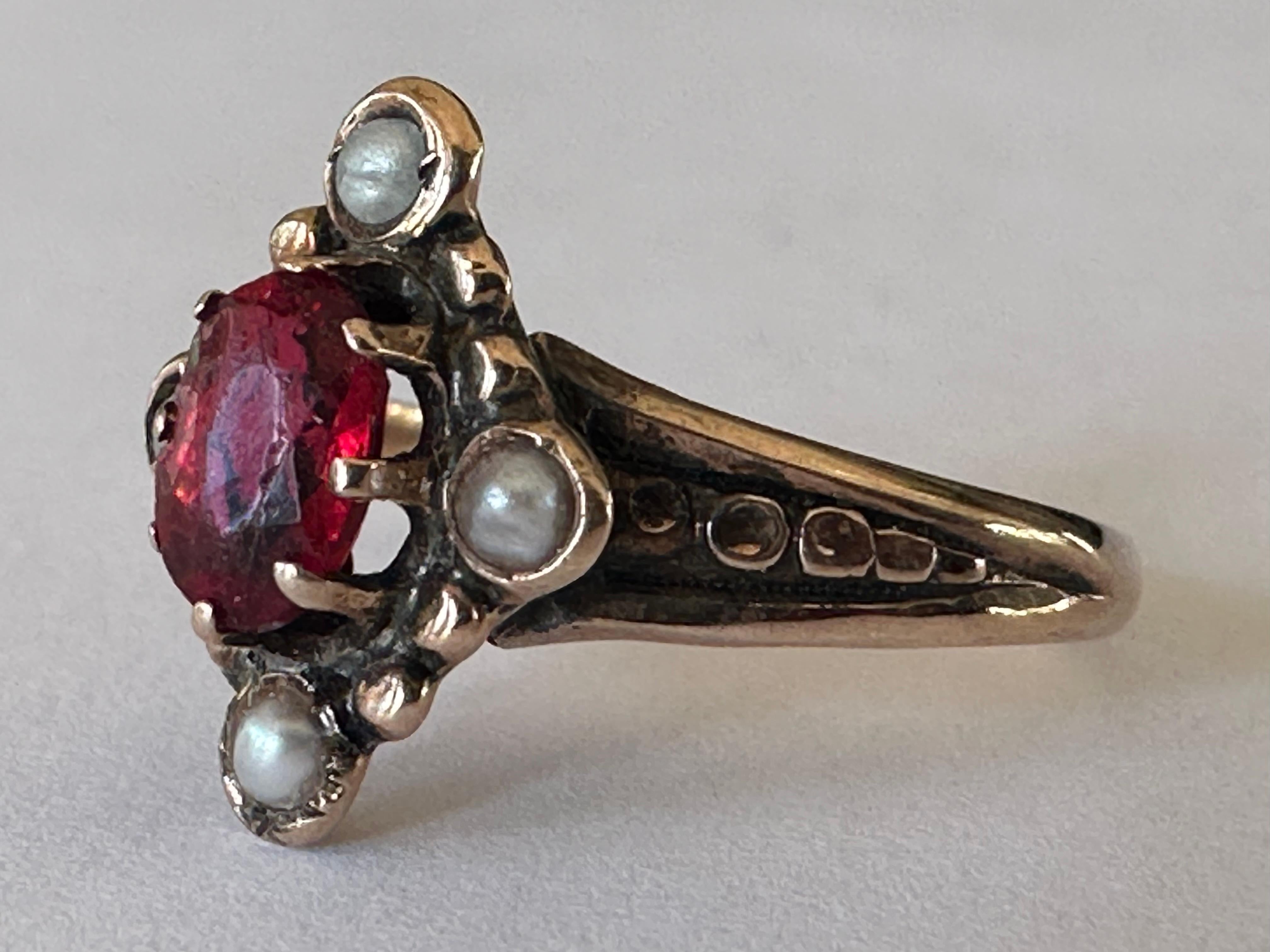 Crafted in the late nineteenth century, this antique navette shaped dinner ring is designed around an oval red garnet and accented by four seed pearls. Set in 10K rose gold. 
