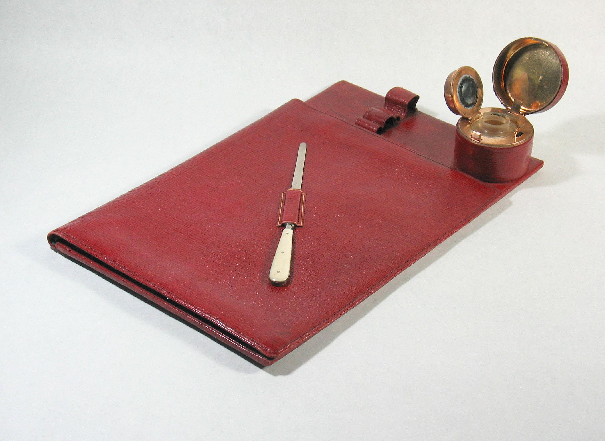 ANTIQUE VICTORIAN RED MOROCCO LEATHER
DESK OR TRAVELLING BLOTTER WITH INKWELL
Late 19th century.

Rare antique Victorian  desk stationery blotter folder with paper knife and unusual feature, built-in gilt brass and glass inkwell.
Made in Vienna and