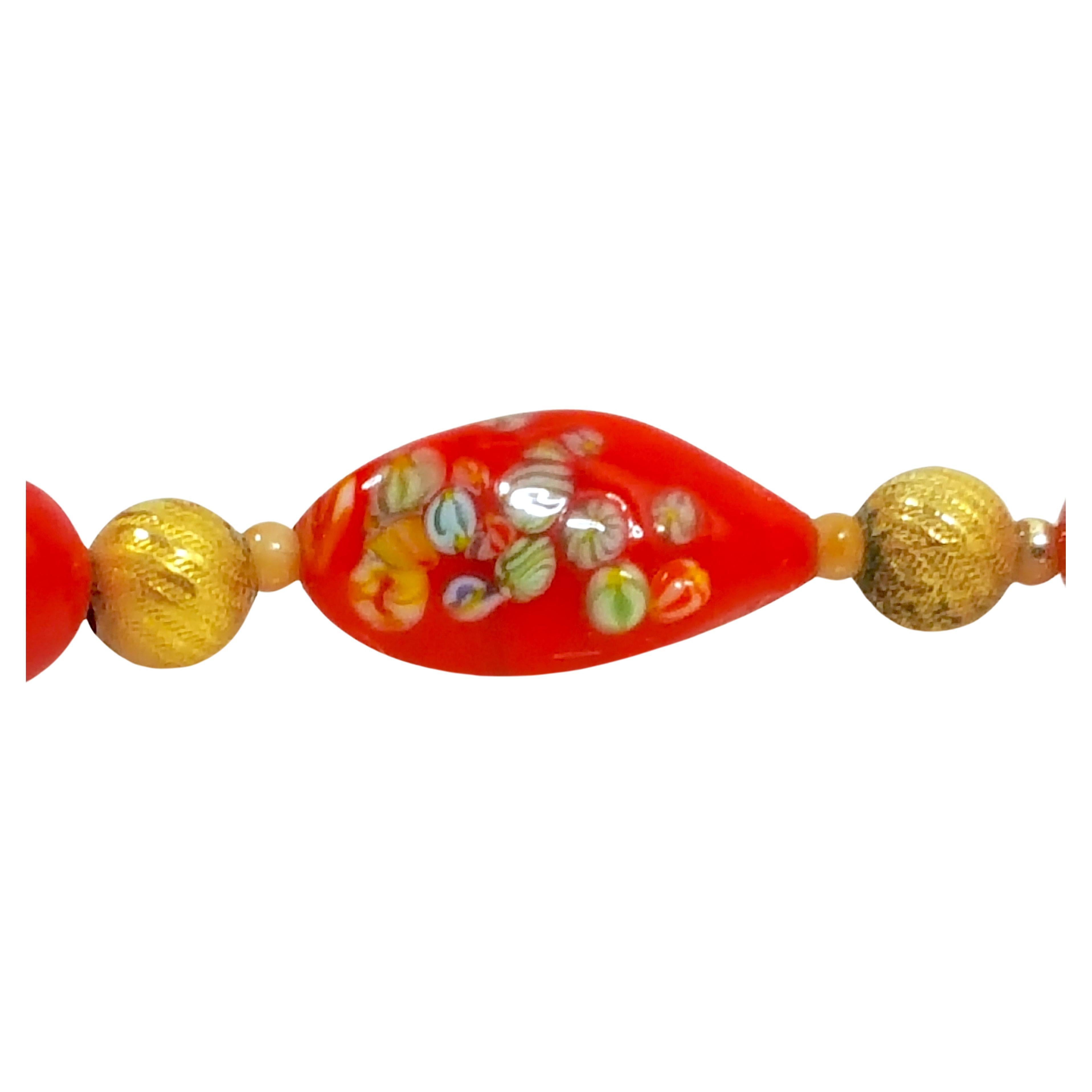 This antique late-Victorian Italian Murano-glass unsigned necklace features three oblong red beads with miniature multicolor swirled-stripe patterns made with the millefiori technique, along with rounds beads that include yellow-gold gilt brass