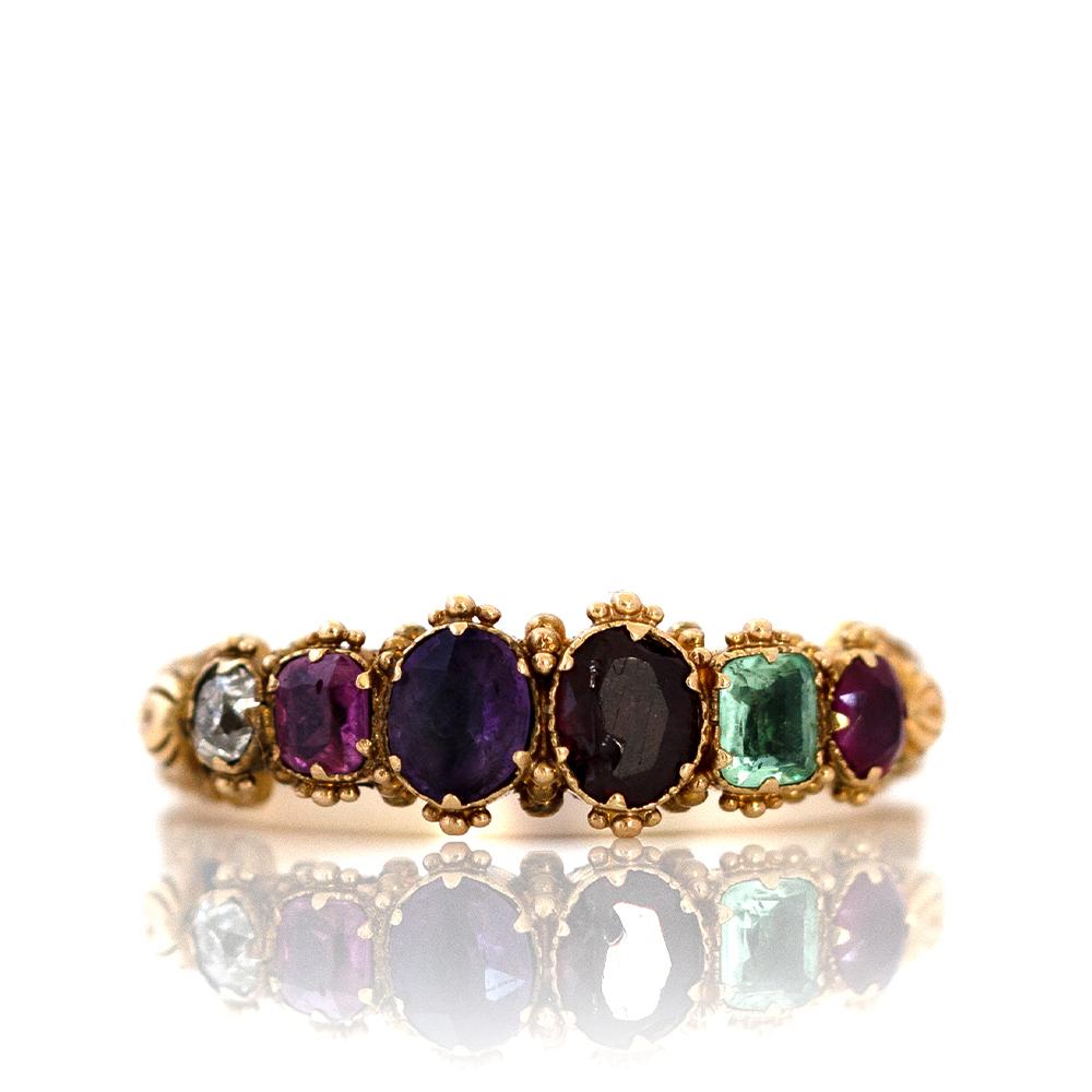 A sentimental treasure from the Victorian era c. 1850s–1870s, this exquisite REGARD acrostic ring spells out the word “REGARD” using a sequence of gemstones: Ruby, Emerald, Garnet, Amethyst, Ruby, Diamond — each chosen for the first letter of its