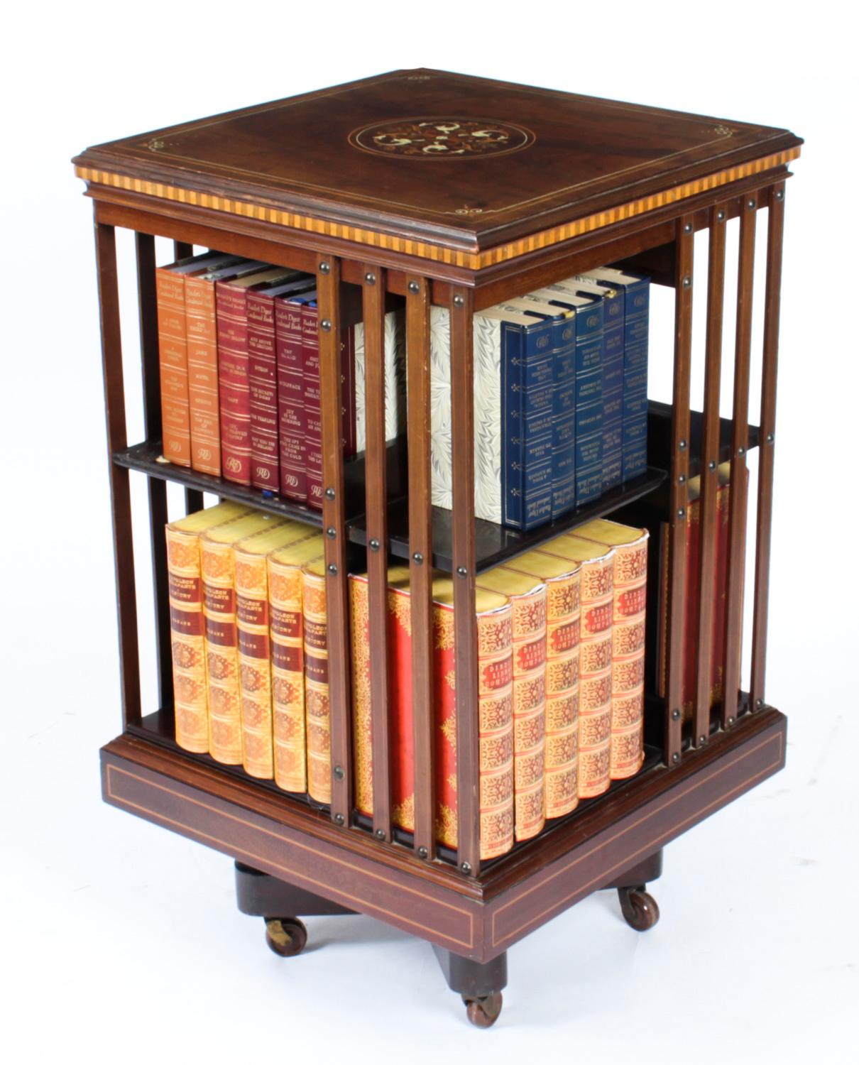 This an exquisite antique Victorian revolving bookcase, circa 1880 in date.

It is made of mahogany , revolves on a solid cast iron base, has inlaid boxwood lines to the top and bottom, the top with elaborate Renaissance Revival dolphin inlay to the