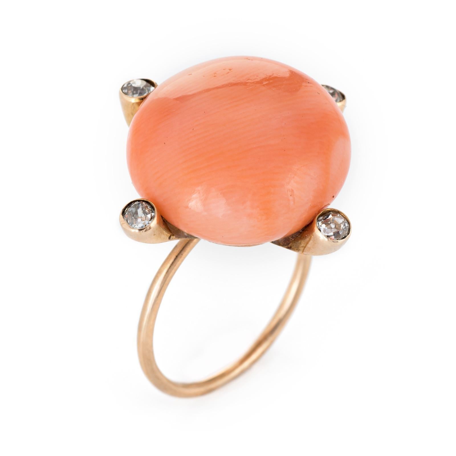 Finely detailed antique Victorian era ring (circa 1880s to 1900s) crafted in 14k yellow gold. 

Coral cabochon measures 18mm diameter, accented with four estimated 0.05 carat old mint cut diamonds. The total diamond weight is estimated at 0.20