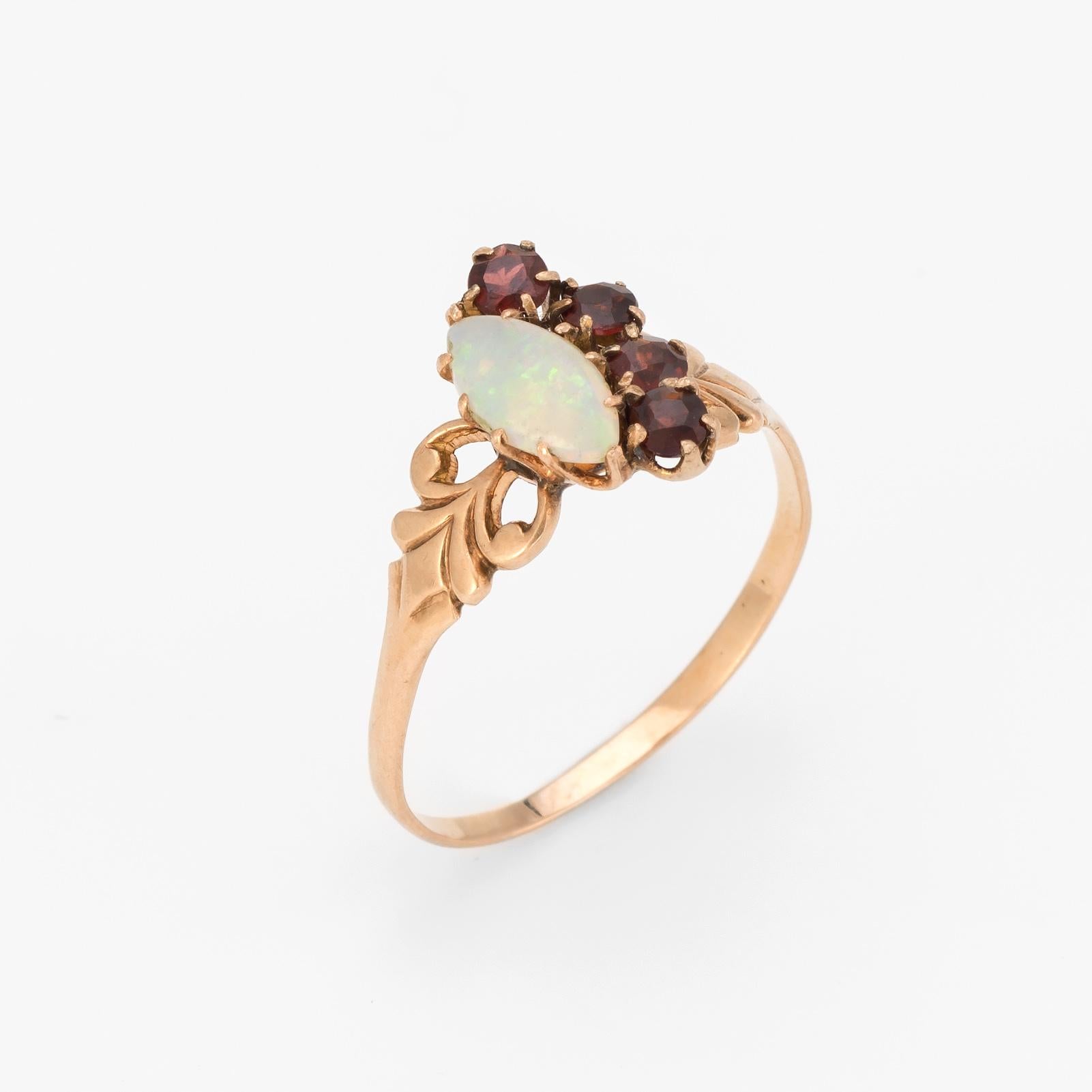 Finely detailed antique Victorian garnet & opal ring (circa 1880s to 1900s), crafted in 10 karat rose gold. 

Four garnets are estimated at 0.06 carats each (0.24 carats total estimated weight), accented with a natural opal that measures 8mm x 4mm