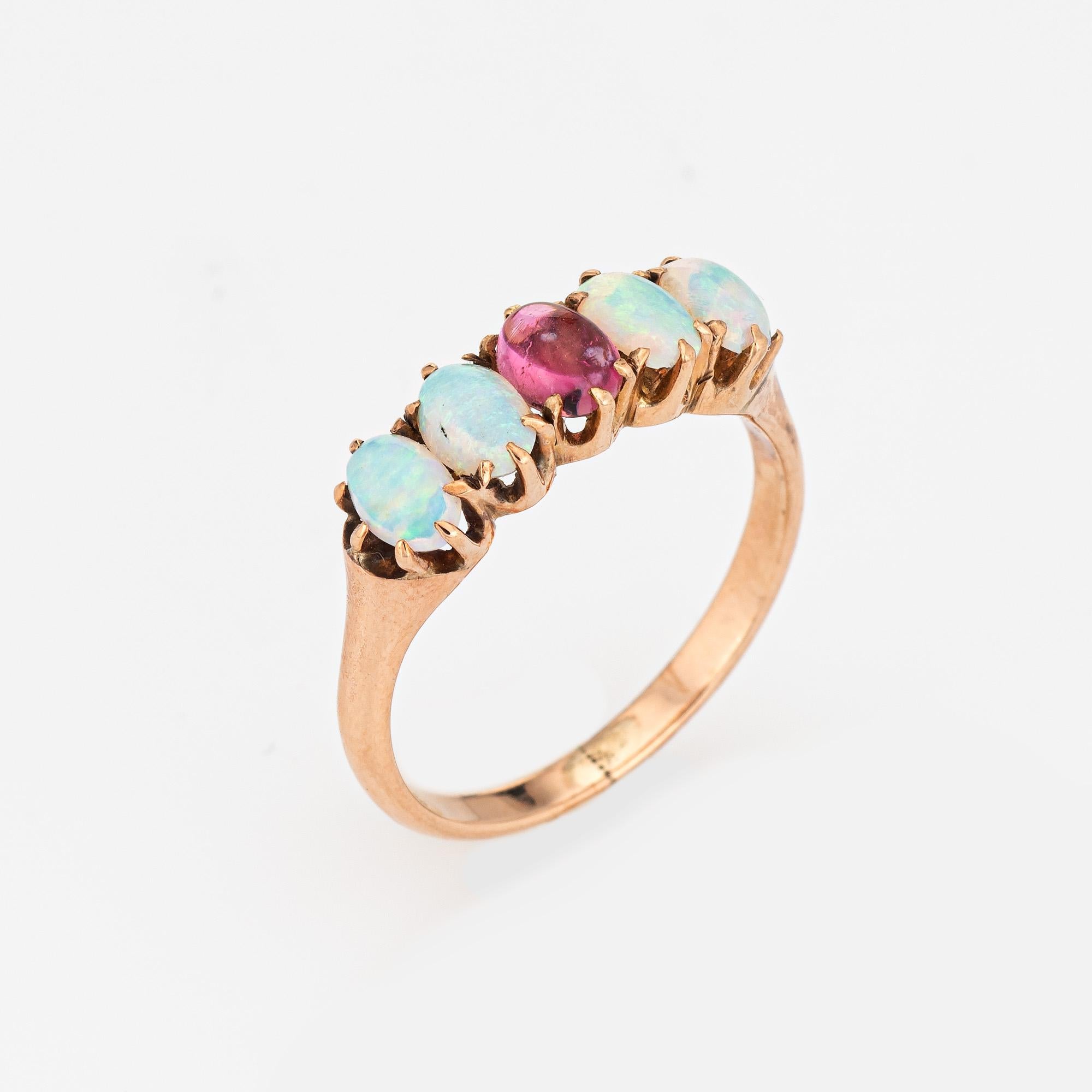 Elegant antique Victorian ring (circa 1880s to 1900s), crafted in 10 karat rose gold. 
Four opals are estimated at 0.20 carats each (0.80 carats total estimated weight), accented with one estimated 0.20 carat cabochon cut pink tourmaline. The pink