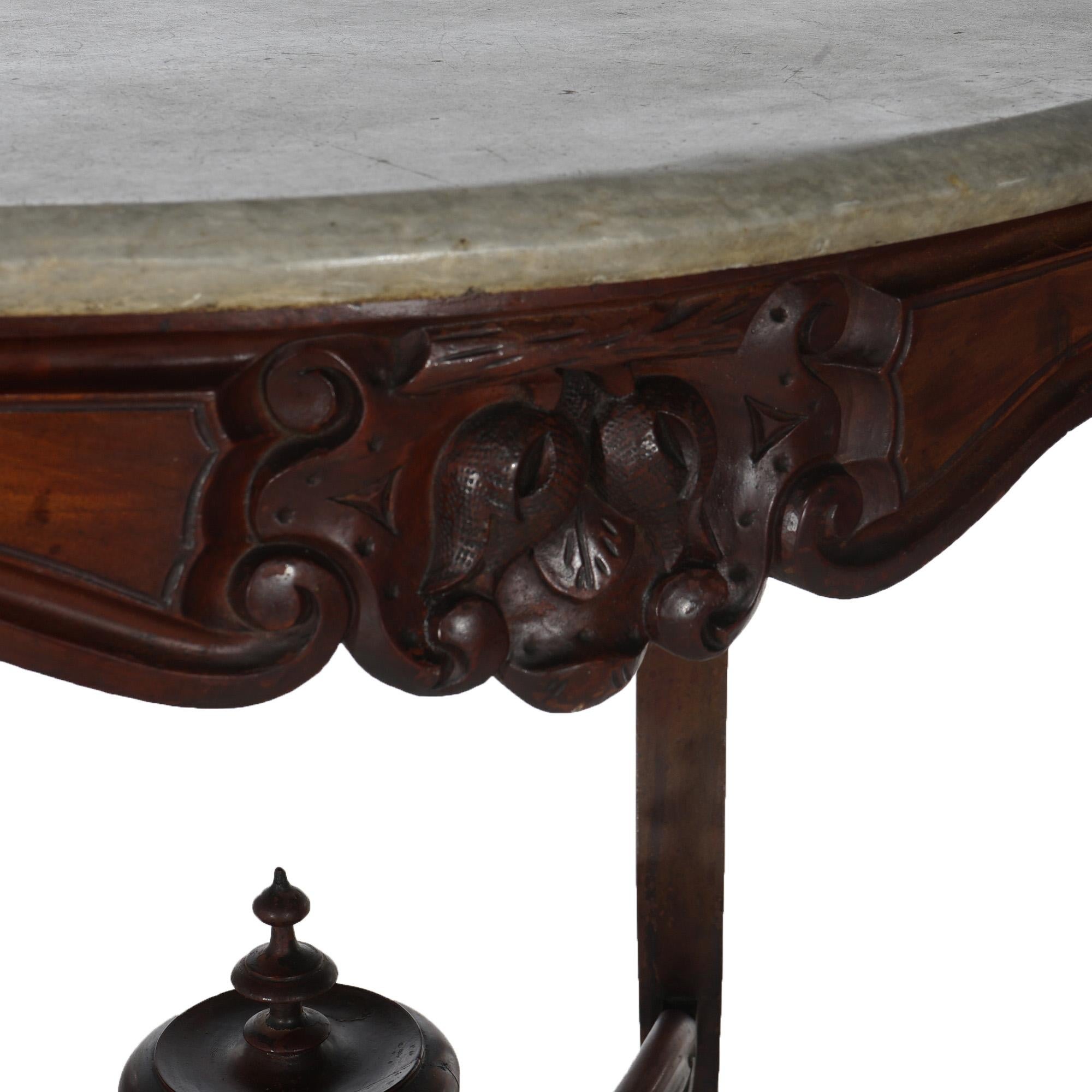 ***Ask About Reduced In-House Delivery Rates - Reliable Professional Service & Fully Insured***

An antique Victorian parlor table offers shaped and beveled marble top over walnut base having carved foliate, nut and scroll elements, raised on
