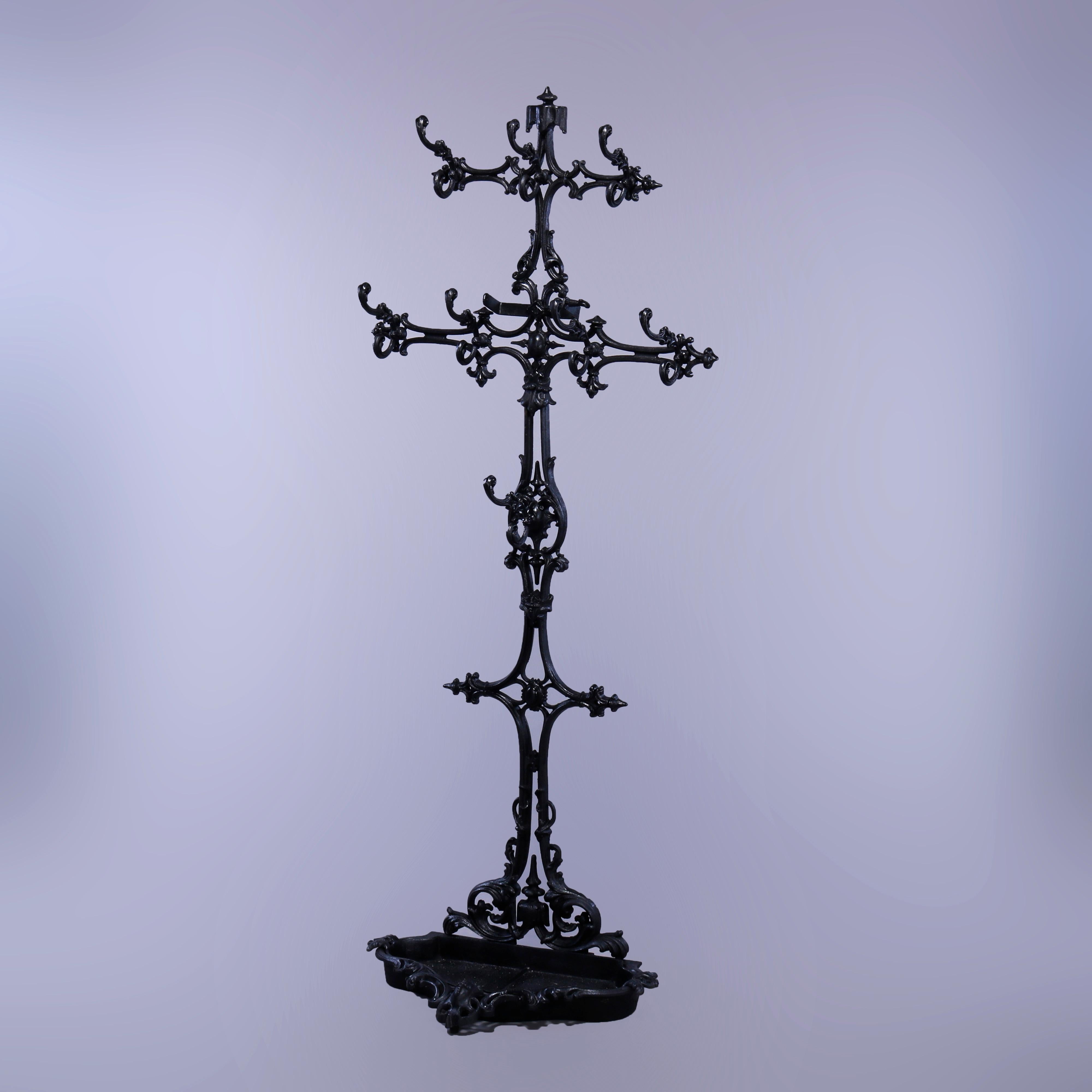 Antique Victorian Rococo hall tree offers cast iron construction in scroll, foliate, cross and stylized star form having shaped umbrella tray at base, c1880

Measures - 75''h x 35.75''w x 17''d.