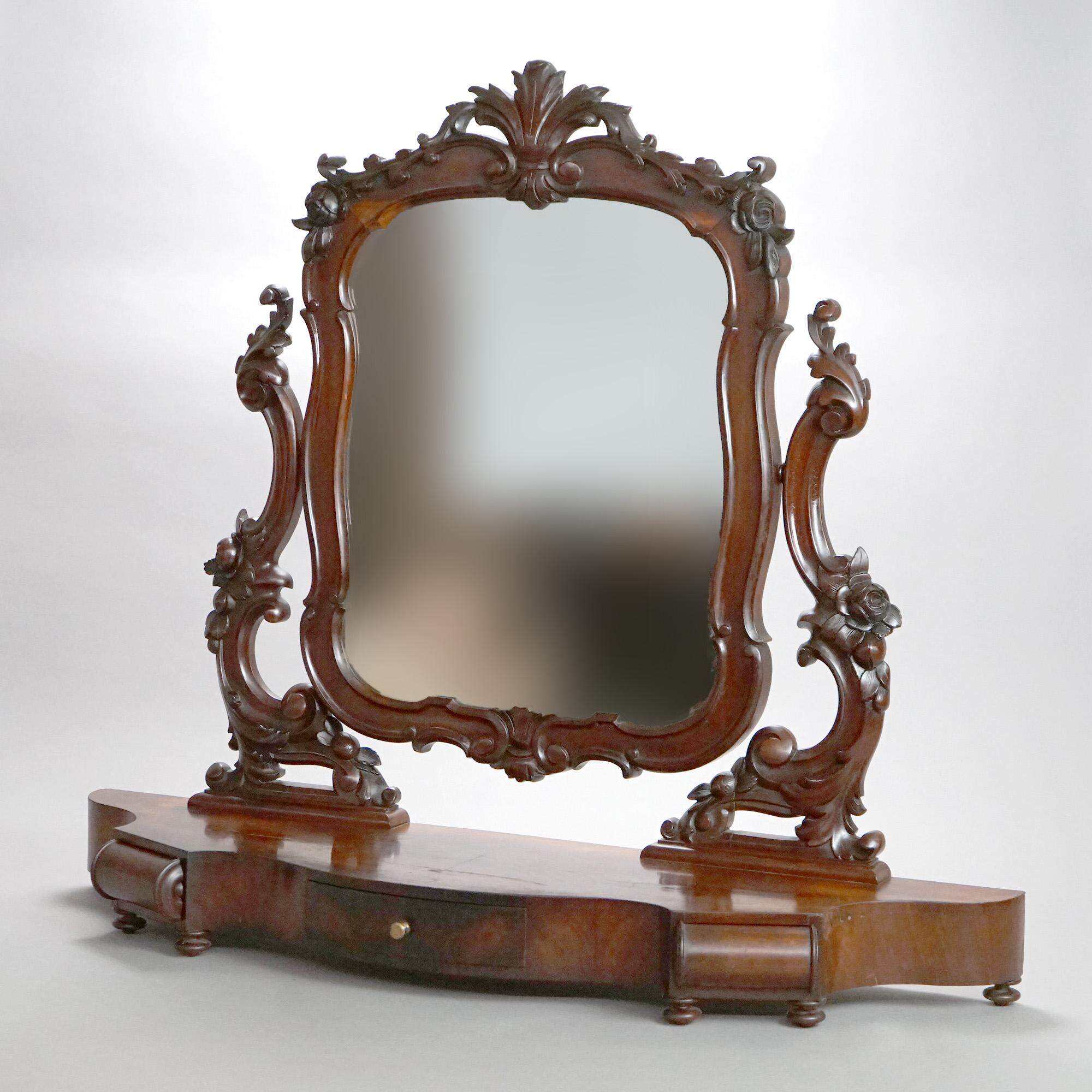 Ein antiker viktorianischer Rokoko-Rasierspiegel bietet eine Flammenmahagoni-Konstruktion mit einem geformten Spiegel, der einen geschnitzten, blattförmigen Rahmen hat, der auf einem Fußsockel mit einer einzelnen Schublade sitzt, um 1890

Maße -