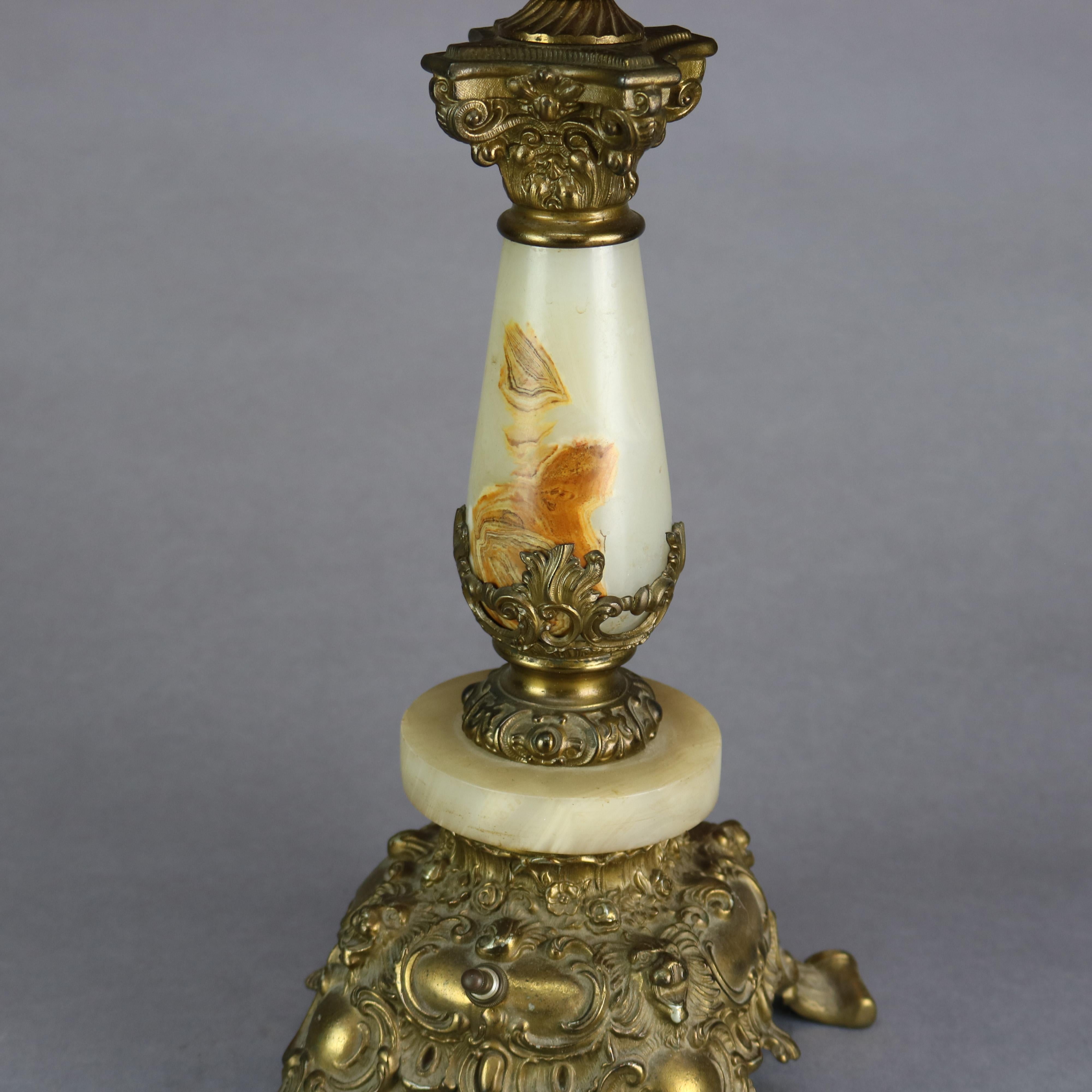 An antique Victorian Rococo parlor lamp offers hand painted floral shade surmounting base with pierced gilt metal foliate and scroll font with onyx column seated on embossed base having scroll form feet, electrified, c1890.

Measures: 32.5