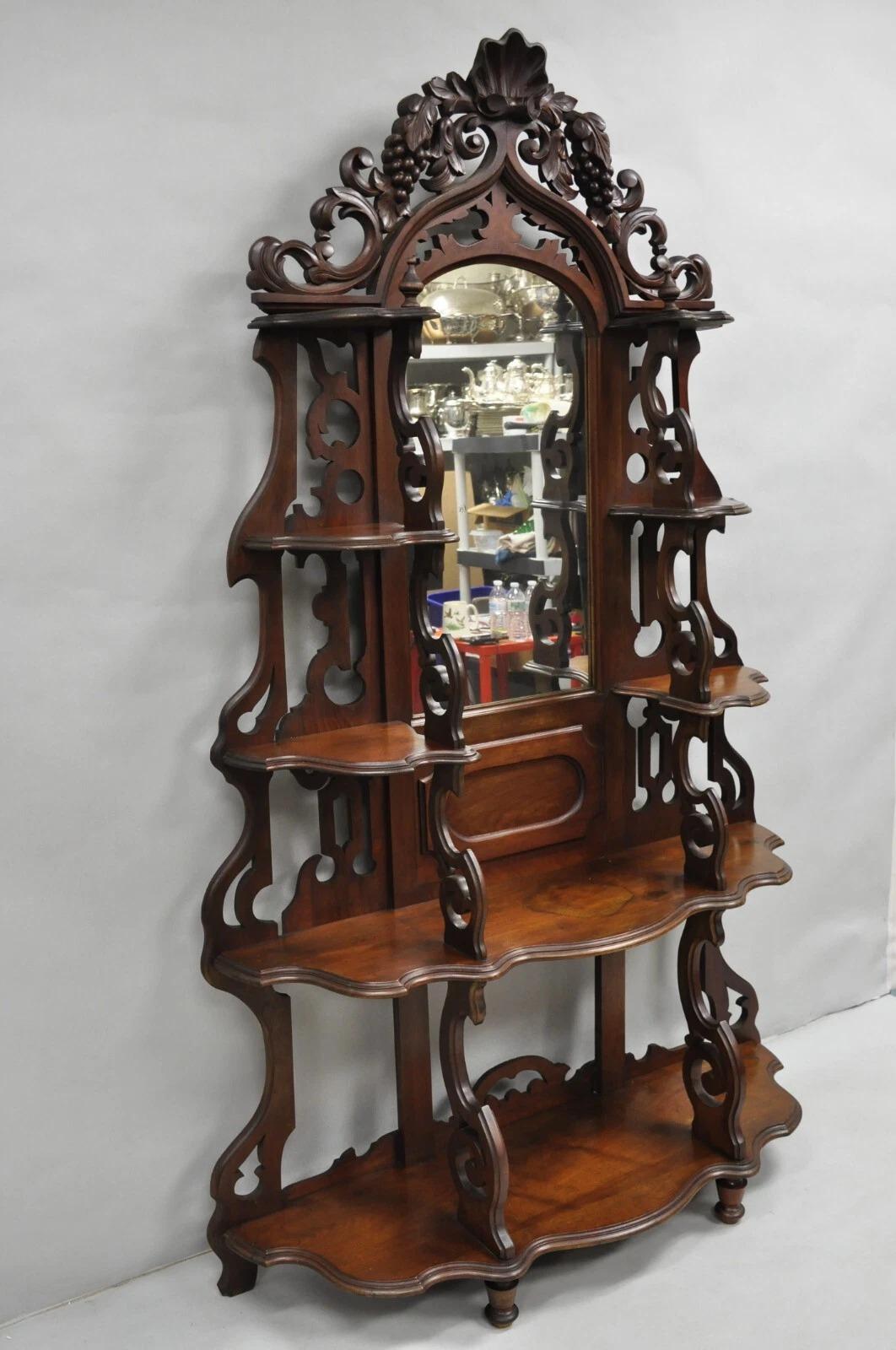 Antique Victorian Rococo Grapevine Carved Walnut Ornate Etagere Curio Shelf with Central Mirror and Multiple Shelves. Circa Late 19th Century. Measurements: 80