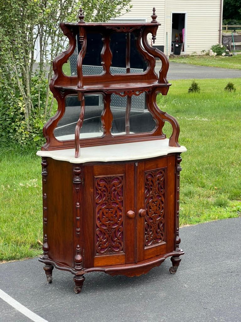 Adéntrate en el opulento mundo de la época victoriana con esta antigua estantería victoriana de mármol de estilo rococó. Verdadera obra maestra de mediados del siglo XIX, este etagere ejemplifica el extravagante y ornamental estilo del Renacimiento