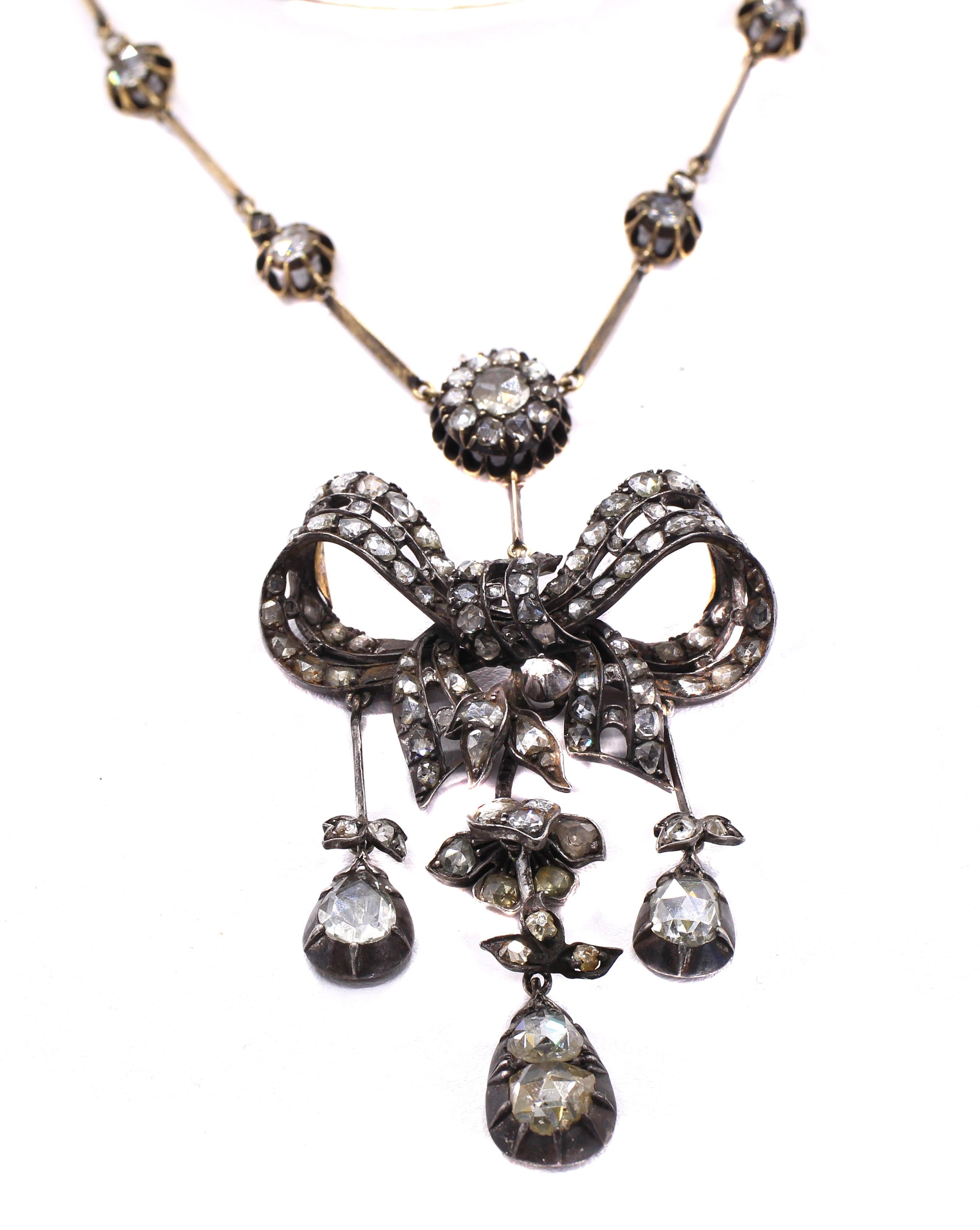 Beautiful early Victorian necklace from ca 1860 worked in silver on gold set with rose cut diamonds. The center piece designed as a bow with 3 flexible pendant elements extending set with 2 larger pear shape rose cuts and 1 round rose cut diamond.