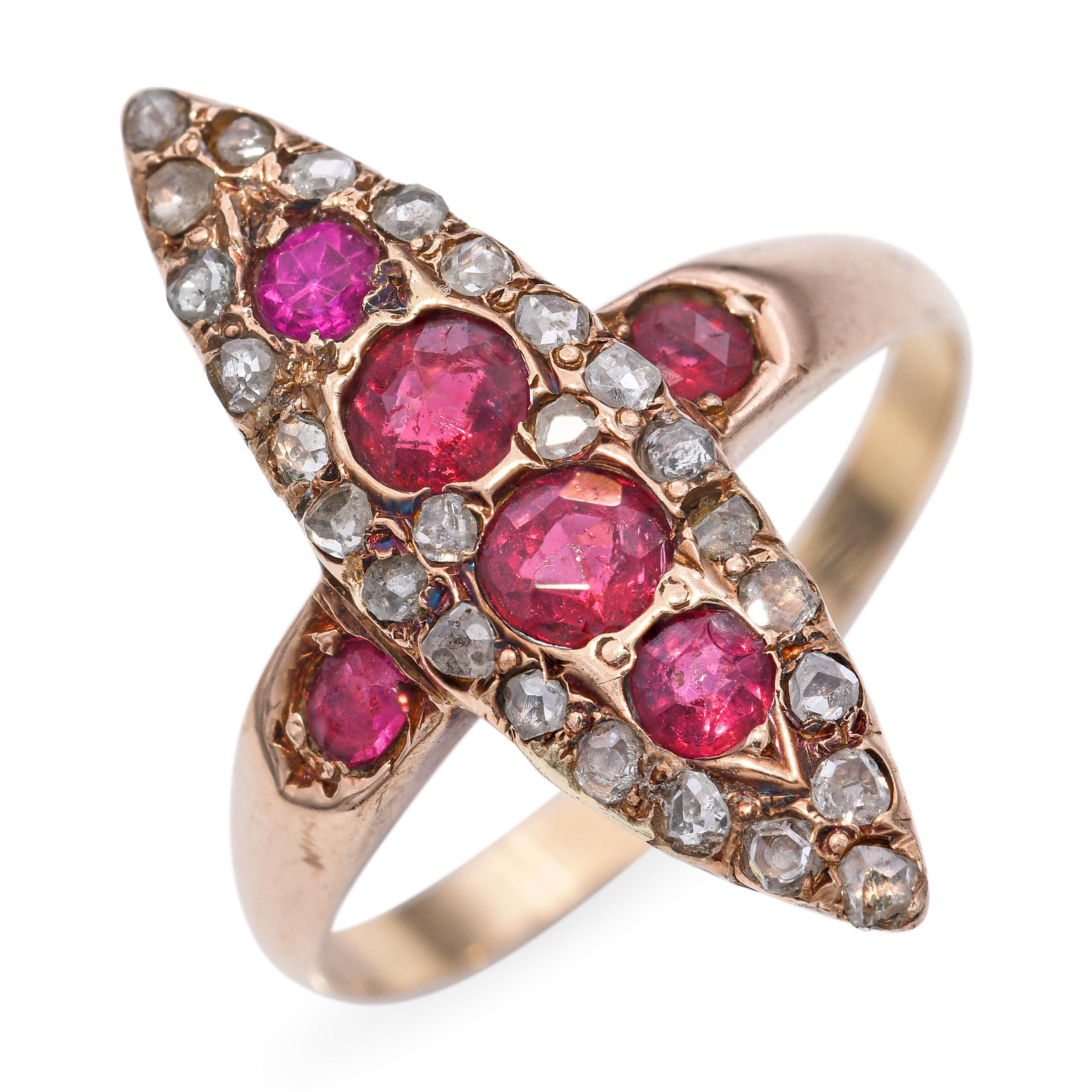A striking example of Victorian elegance, this navette-shaped ring showcases a vibrant arrangement of richly hued rubies accented by glittering rose-cut diamonds. The elongated design, a hallmark of the period, creates a flattering silhouette across