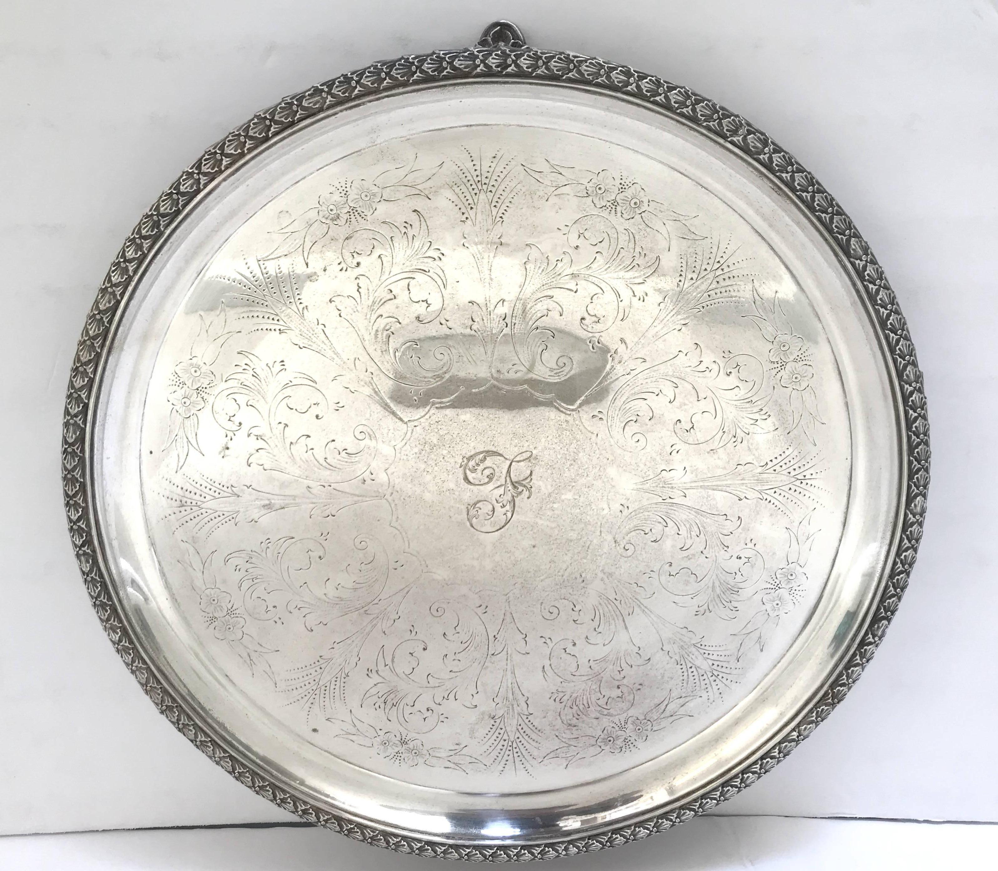 Bandeja o fuente redonda inglesa victoriana antigua de plata para servir, apoyada sobre tres pies, con un hermoso follaje grabado y repujado y una letra 