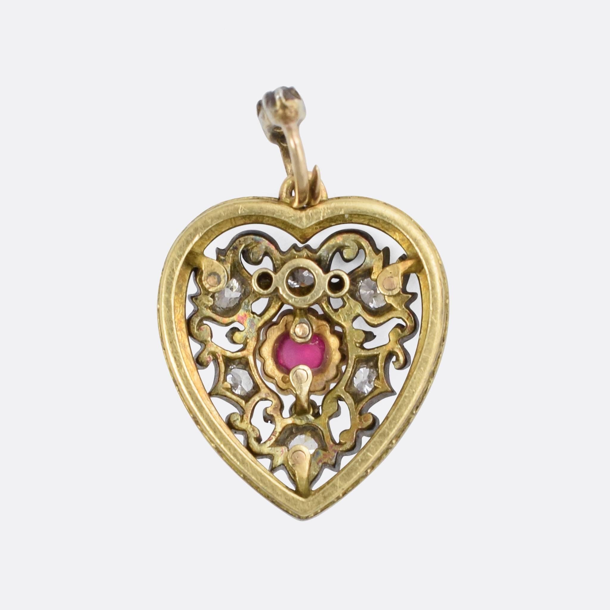 A beautiful Victorian Heart Pendant, set with a natural ruby cabochon and old mine cut diamonds. The diamonds rest in intricate openworked mounts, bordered with white enamel, and complete with the original diamond-set bail. Modelled in 18k gold with