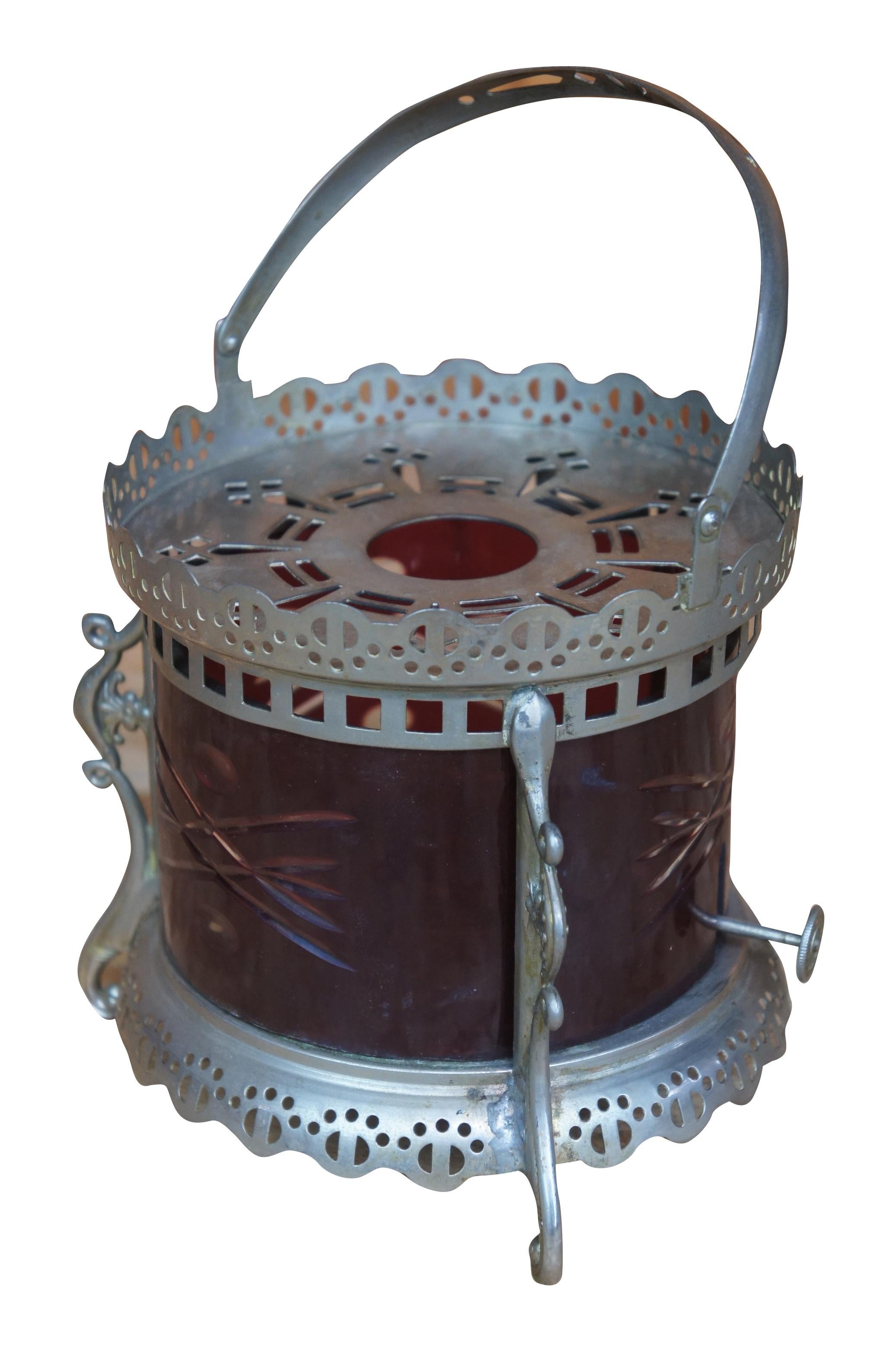 Antique Victorian oil lantern or lamp. Made of metal with reticulated design featuring serpentine footed base and pierced handle with ruby cut to clear cylidrical etched glass hurricane insert. Measure: 6