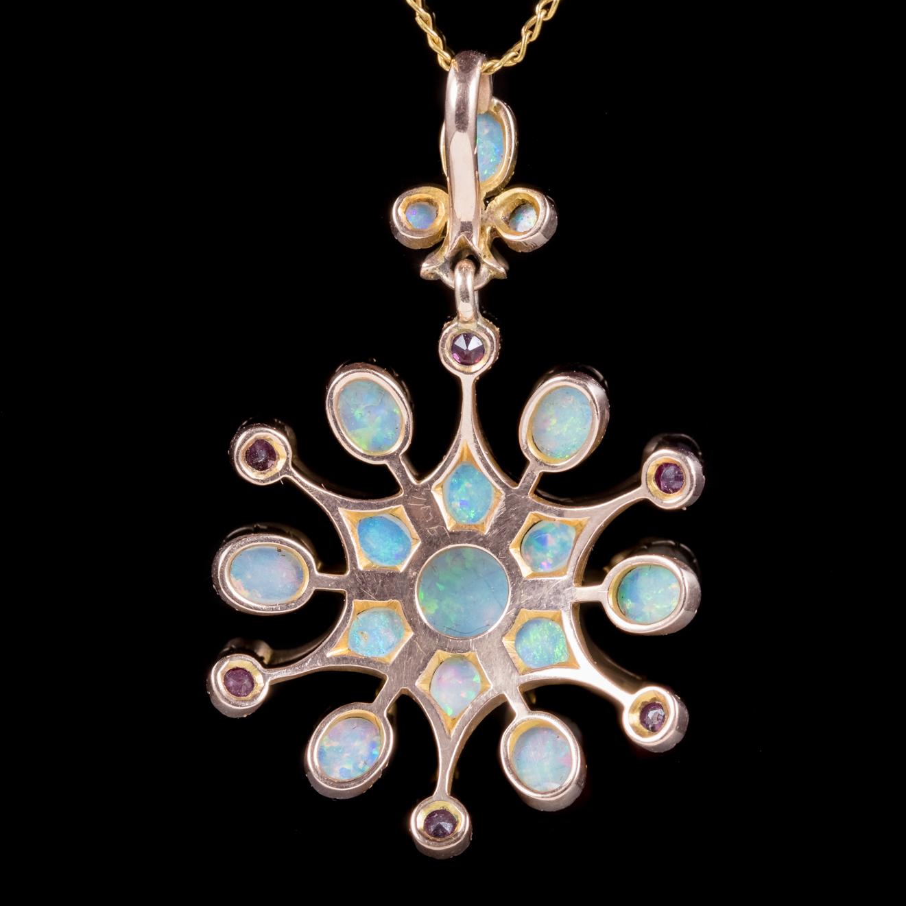 A genuine antique Victorian necklace C. 1880, featuring a fabulous pendant decorated with a starburst of natural Opals and rich red Rubies. 

The central Opal measures 0.80ct alone with smaller colourful Opals spread throughout the gallery and bale.