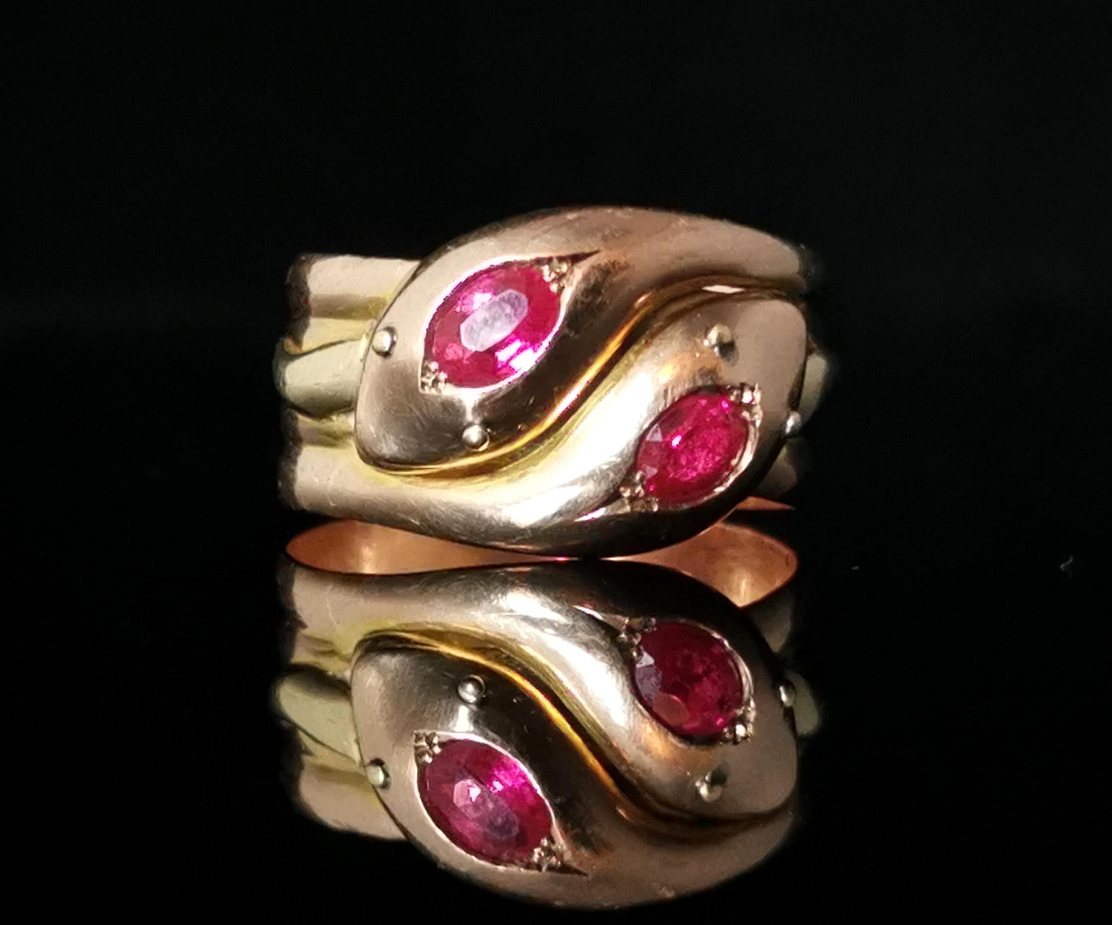 An impeccable antique, Mid Victorian Ruby snake ring.

Coils and coils of rich buttery 9 karat, antique yellow gold forming the entwined bodies of two snakes, the heads are both well detailed and both set with a gorgeous rich reddish Pink antique