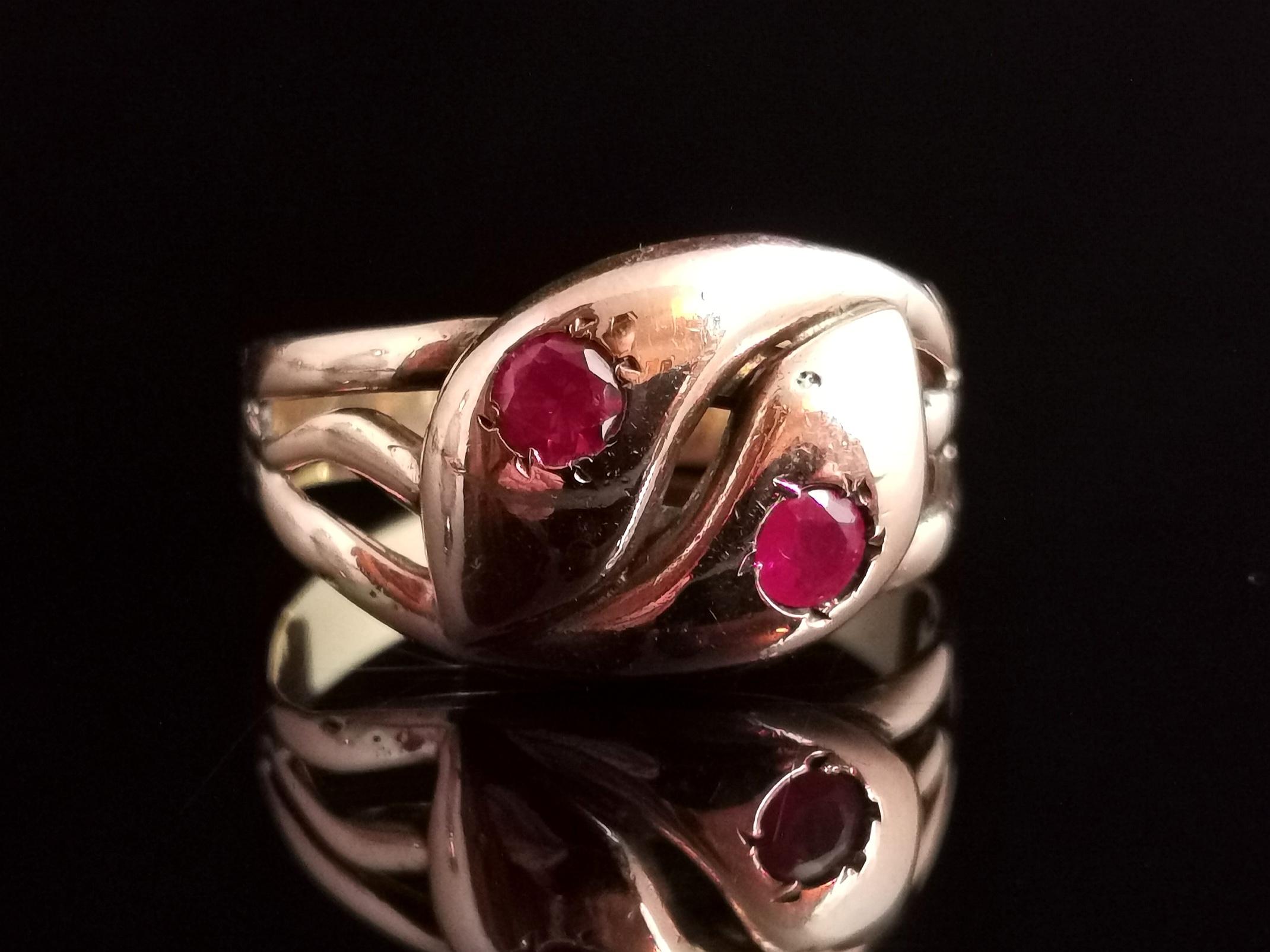 A beautiful antique, late Victorian Ruby snake ring.

Coils of buttery 9ct, antique yellow gold forming the entwined bodies of two snakes, the heads are both well detailed and both set with a gorgeous rich reddish Pink Ruby, it has decorative cut