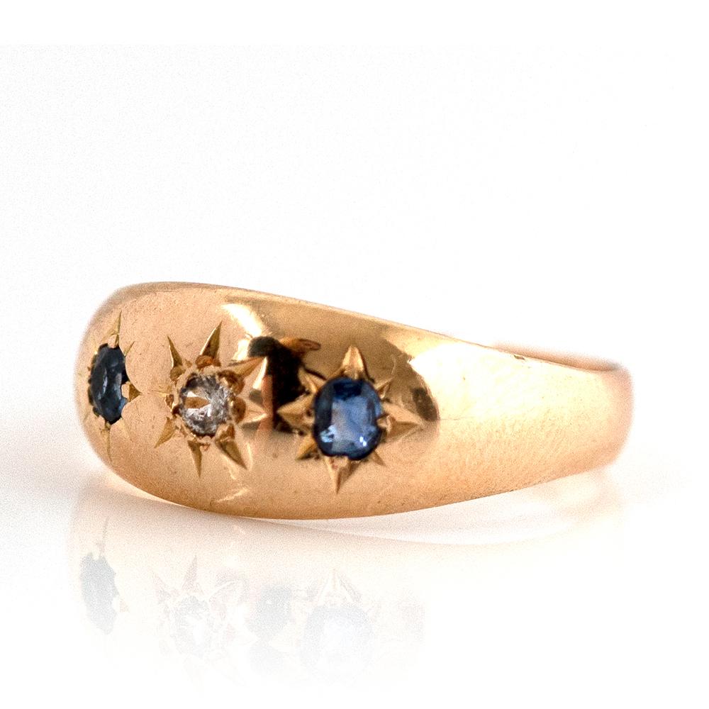 Our antique Victorian sapphire 18ct Gold Ring is the perfect blend of classic elegance and modern sophistication. With two deep blue sapphires and a central diamond this gorgeous 18 carat gold ring is truly a romantic work of art. The style of this