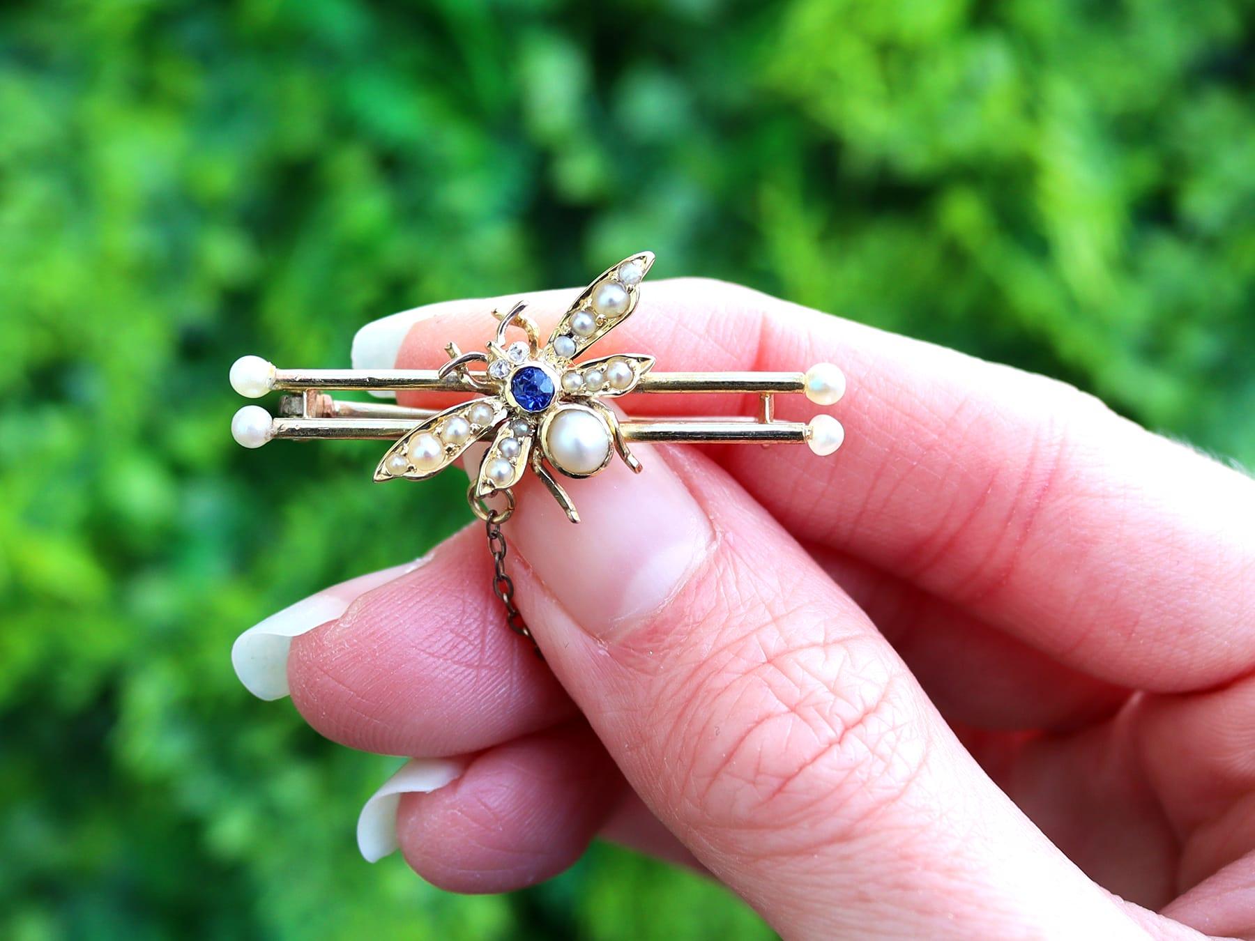 A fine and impressive antique Victorian 0.04 carat diamond and 0.05 carat natural blue sapphire, seed pearl and 15 karat yellow gold brooch in the form of a winged insect; part of our antique jewelry and estate jewelry collections.

This fine and