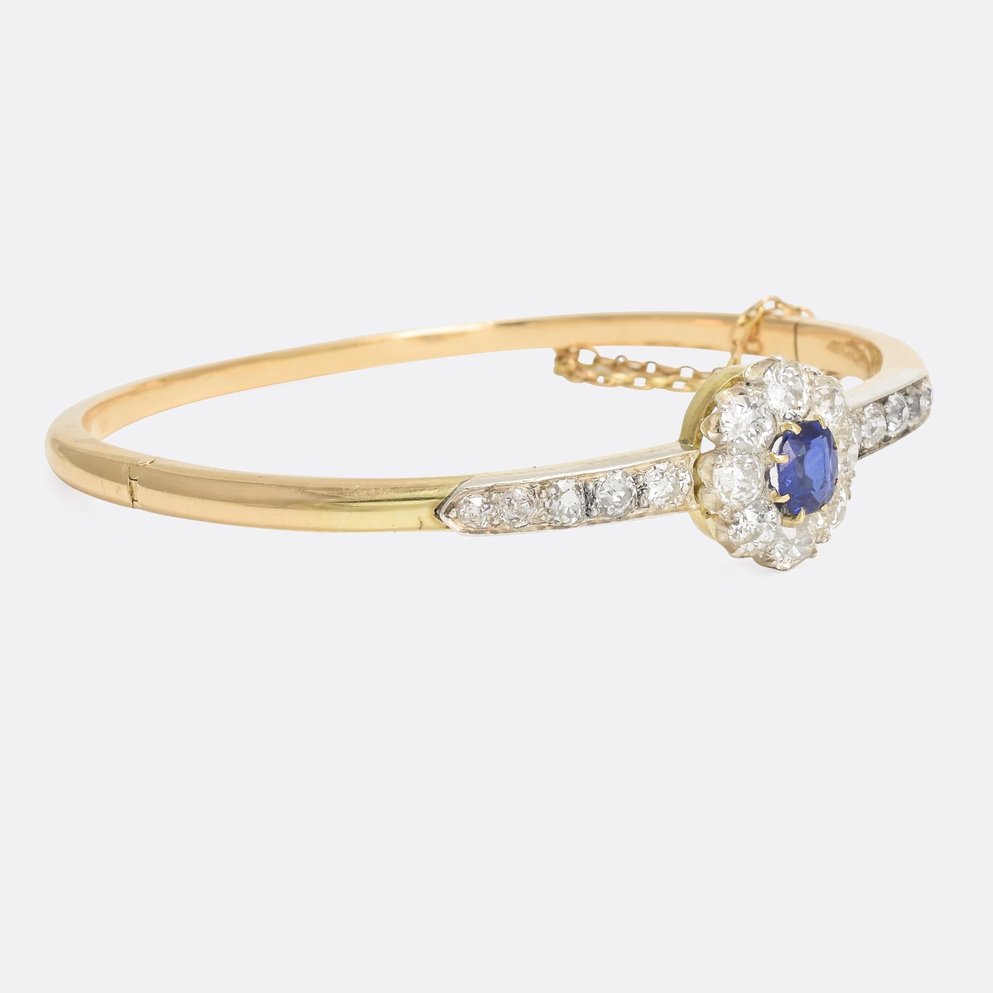 A stunning Victorian bangle, the head set with a vibrant blue sapphire within a cluster of cushion cut diamonds. More diamonds radiate out from the head, mounted in platinum to enhance their colour. It's a beautifully constructed piece that dates