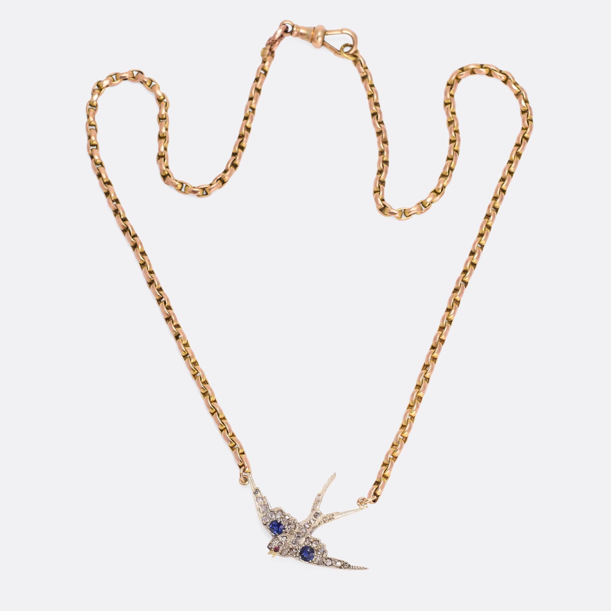 A stunning antique diving swallow necklace; the bird is set with diamonds, sapphires, and a ruby eye, modelled in 15k gold with silver settings. We've added a period gold chain, converting what was once a brooch into a very wearable necklace. 

The