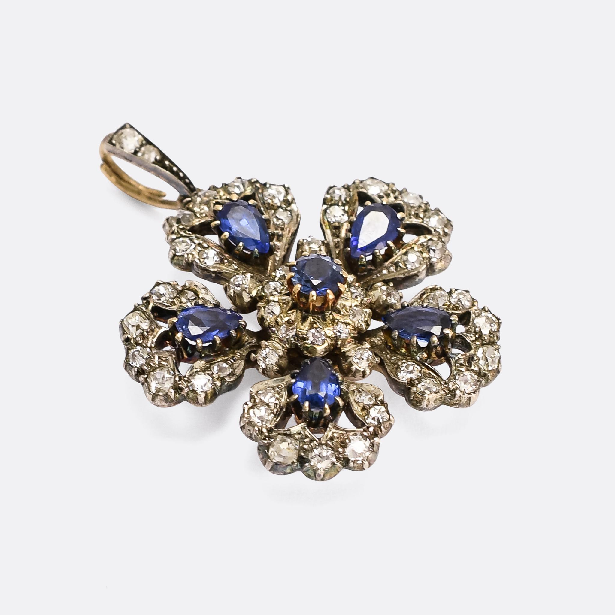 A stunning mid Victorian flower pendant set with vibrant blue sapphires and old mine cut diamonds. It's beautifully constructed, crafted in 15k gold with silver settings, and complete with original diamond-set bail. It was made in England in the