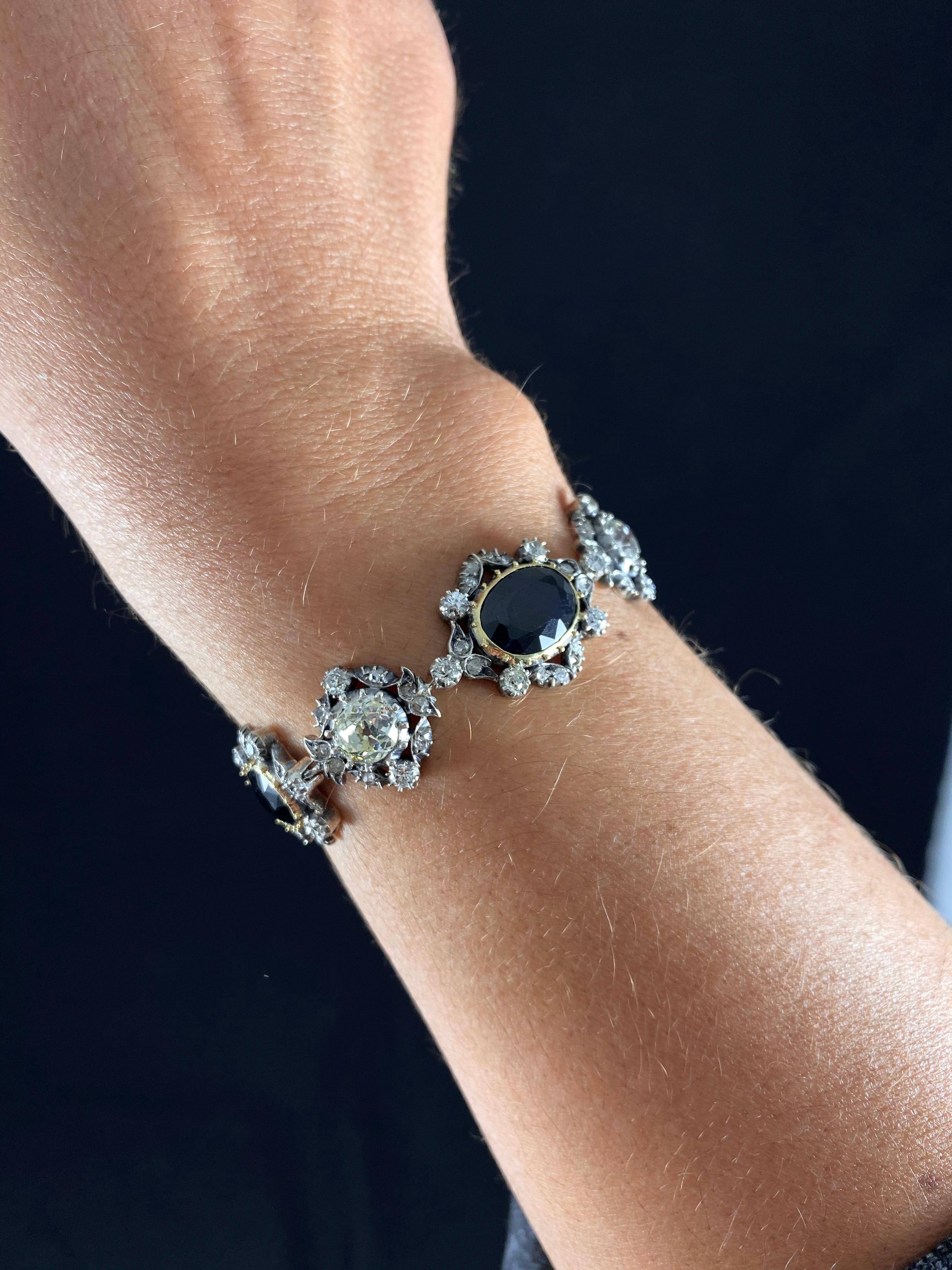 Antique Victorian Sapphire and Old Cut Diamond Bracelet in Yellow Gold and Silver, circa 1890. A late 19th century jewel of floral and foliate design, featuring three mixed-cut oval and elongated cushion-shaped sapphires of a dark blue color and two