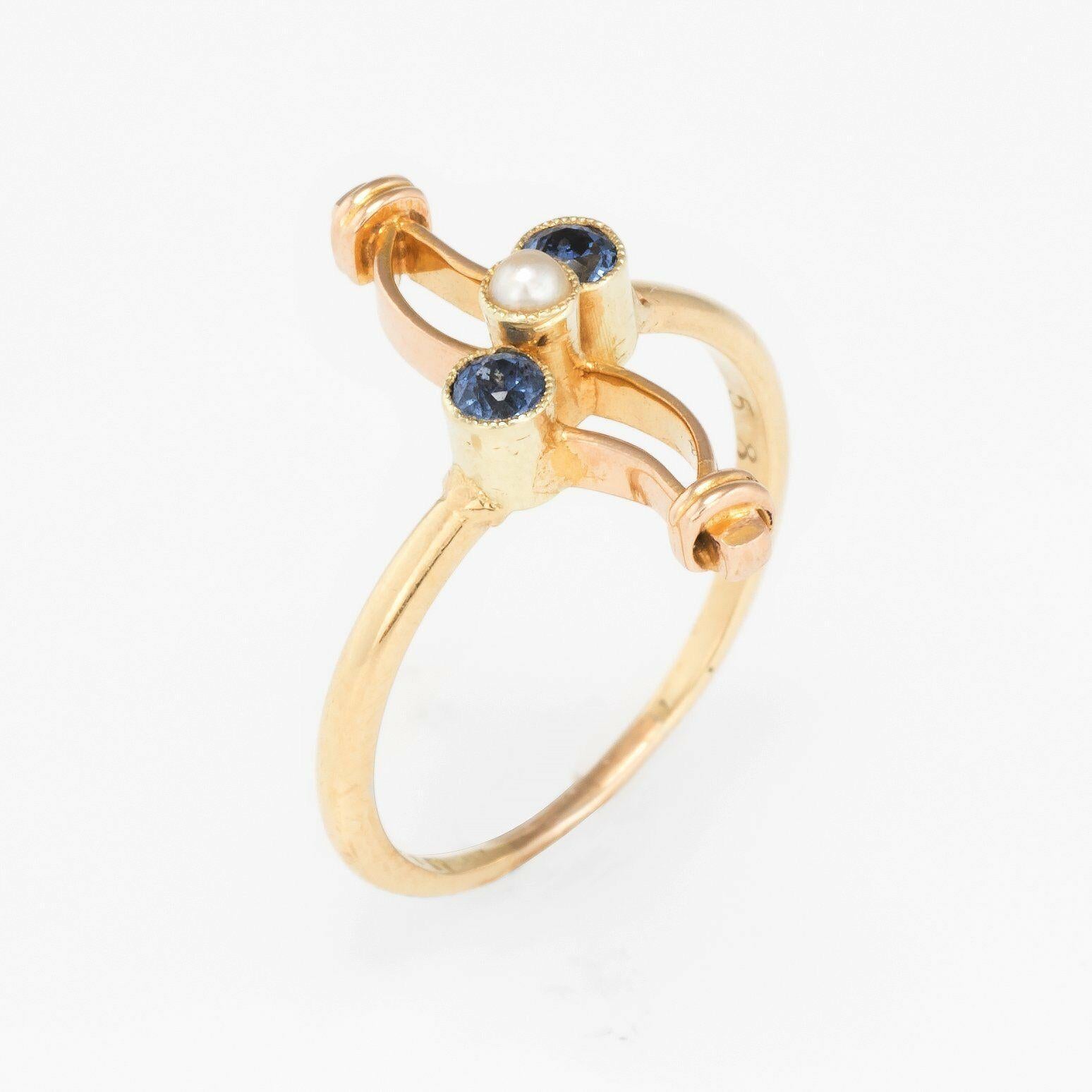 Elegant antique Victorian era ring (circa 1880s to 1900s), crafted in 14 karat yellow gold. 

Centrally mounted blue sapphires are estimated at 0.10 carats each (0.20 carats total estimated weight), accented with one 2.5mm seed pearl. The stones are