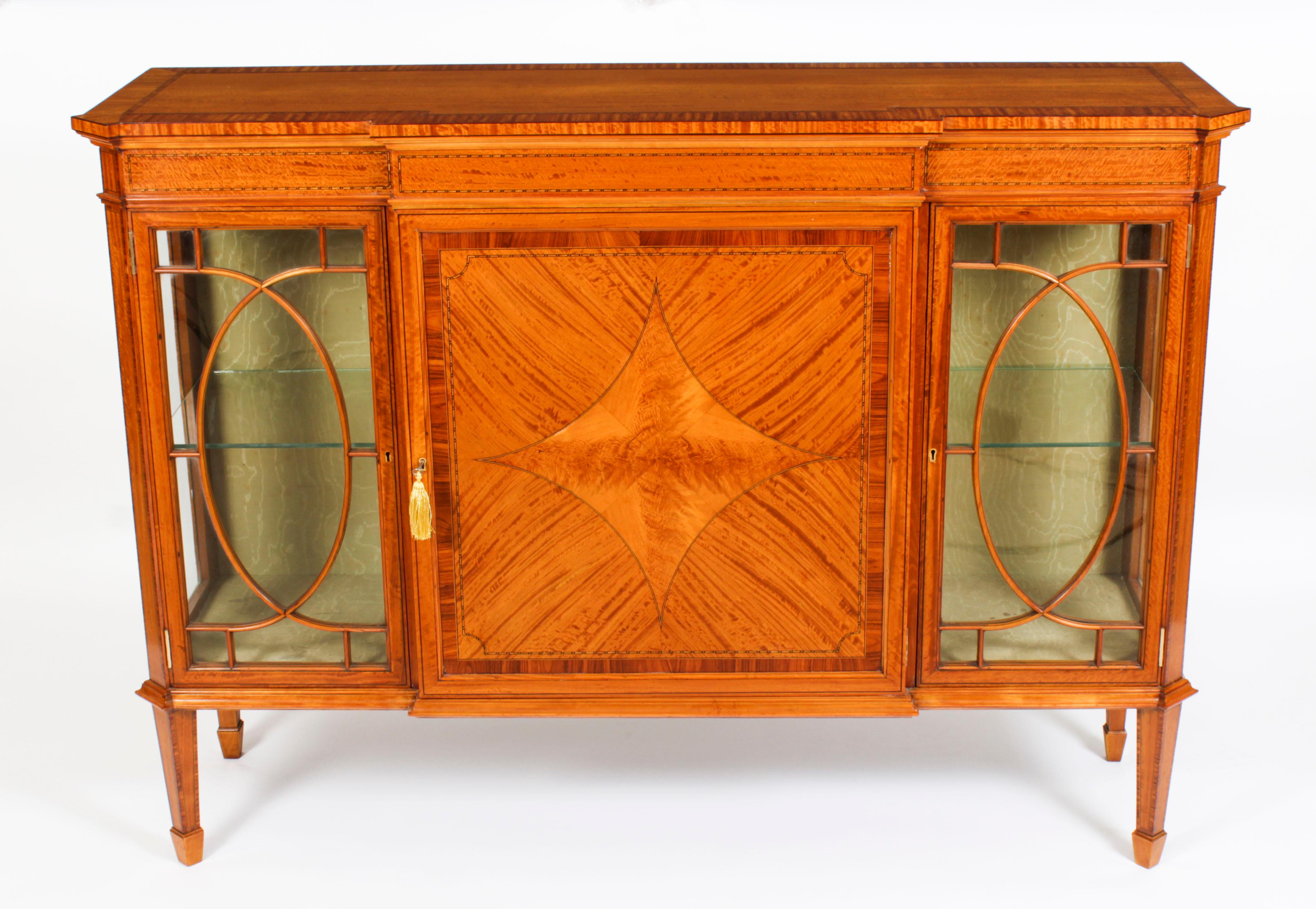 This is a superb antique late Victorian satinwood breakftont display cabinet , circa 1880 in date.

Oozing sophistication and charm, this cabinet is the absolute epitome of Victorian high society. Its attention to detail and lavish decoration are