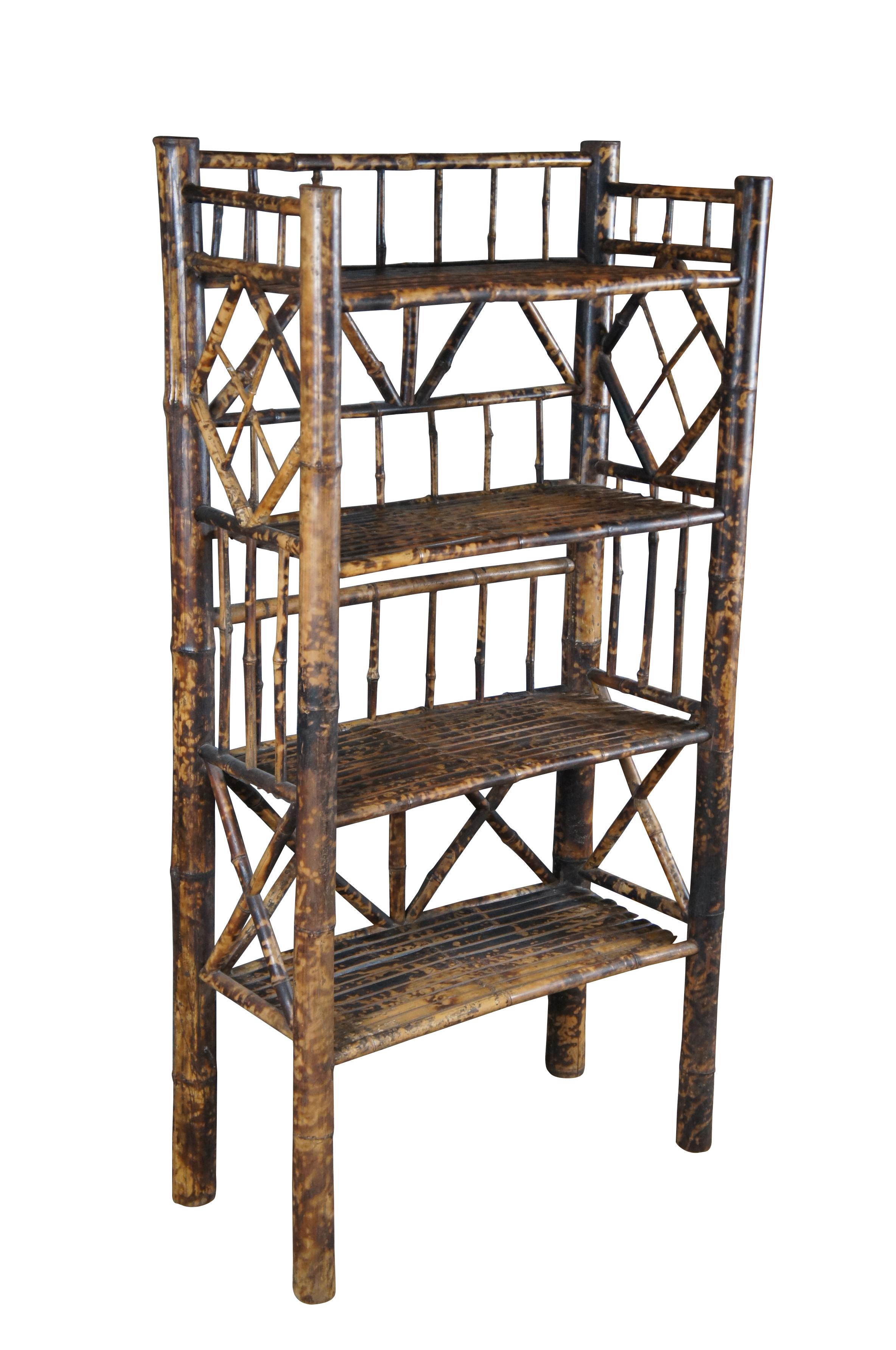 Antique Victorian bamboo library bookcase / etagere stand.  Made of bamboo featuring a scorched / tortoise shell finish with four shelves, columns, and geometric pattern slats. 

Dimensions:
27