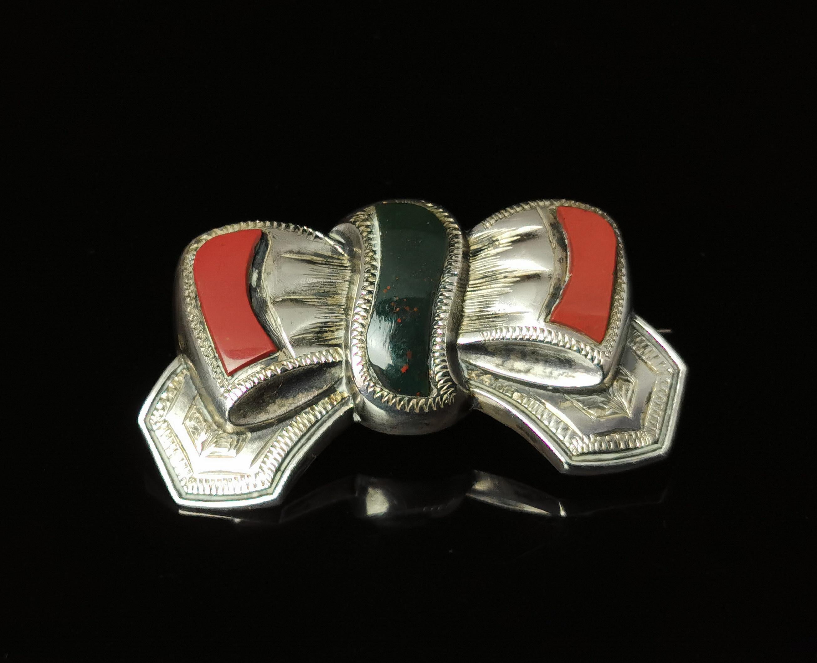 A gorgeous and antique Victorian, Scottish agate and Silver bow brooch.

It is a well designed piece modelled in sterling silver as a tied bow with great attention to detail and fine engraving.

The bow is set with Red Jasper and Bloodstone and it