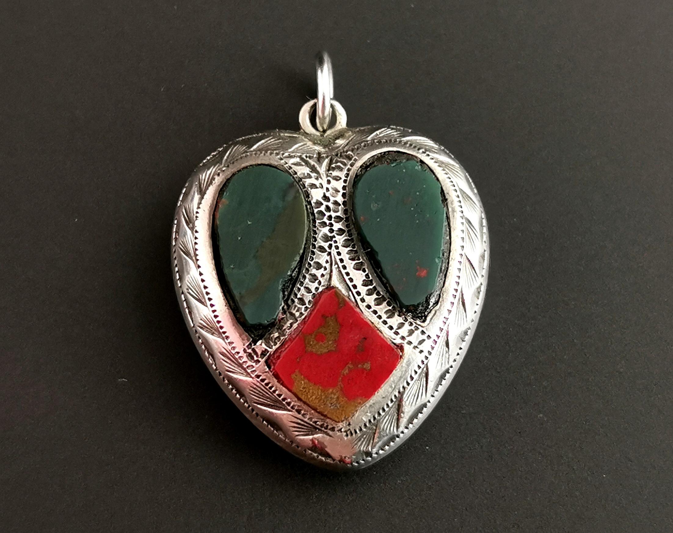 A beautiful little antique Scottish agate and Silver heart pendant.

It is a puffy silver heart with light engraving and a smooth polished finish to the reverse.

The front of the pendant is set to the front with Red Jasper and bloodstone with two