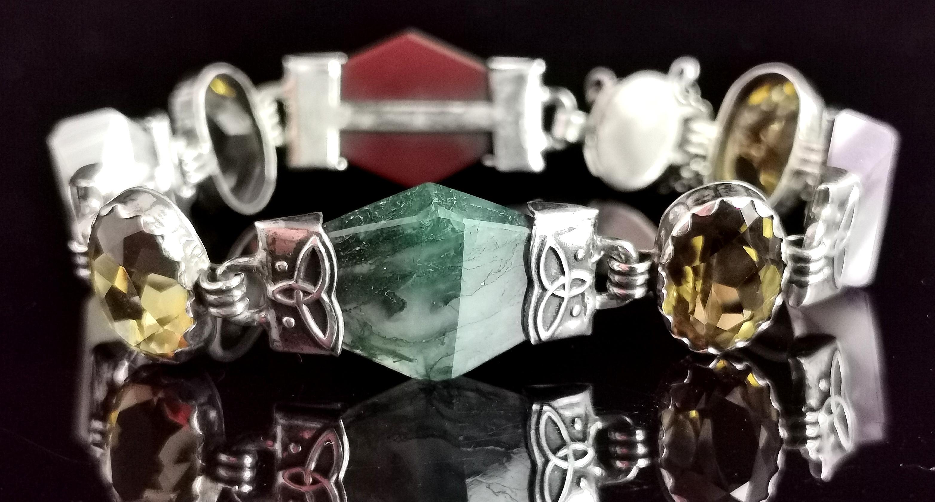 A gorgeous antique, late Victorian era Scottish agate, citrine and Silver bracelet.

The bracelet features beautifully faceted panels of polished agate each with celtic design silver end caps, each of these is intercepted by a faceted oval cut