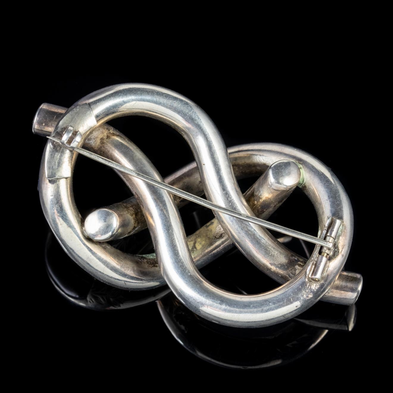 A unique Victorian Scottish brooch in a wonderful interweaving knot design with floral engraved artistry and polished inlaid Agates. 

Scottish jewellery was made popular by Queen Victoria as it became a souvenir of her frequent trips to Scotland