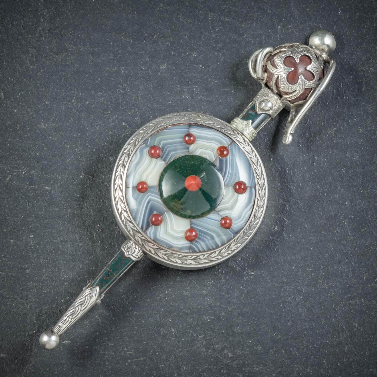 A unique and rarely found antique Scottish sword and shield brooch from the Victorian era, Circa 1860. 

The piece is decorated in lovely earthy coloured Agates which are fashioned to fit the brooches unique shape and polished to perfection. 

There