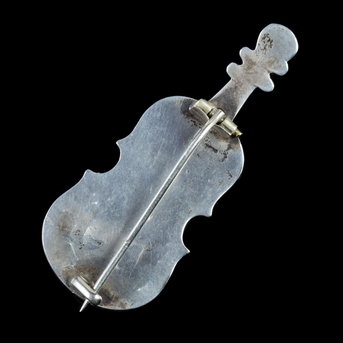 This beautiful antique Scottish Victorian brooch is carved in the likeness of a cello, with four pieces of Scottish Agate set into the top and base of the instrument. The cello’s body has been sculpted in Sterling Silver delicately engraved with