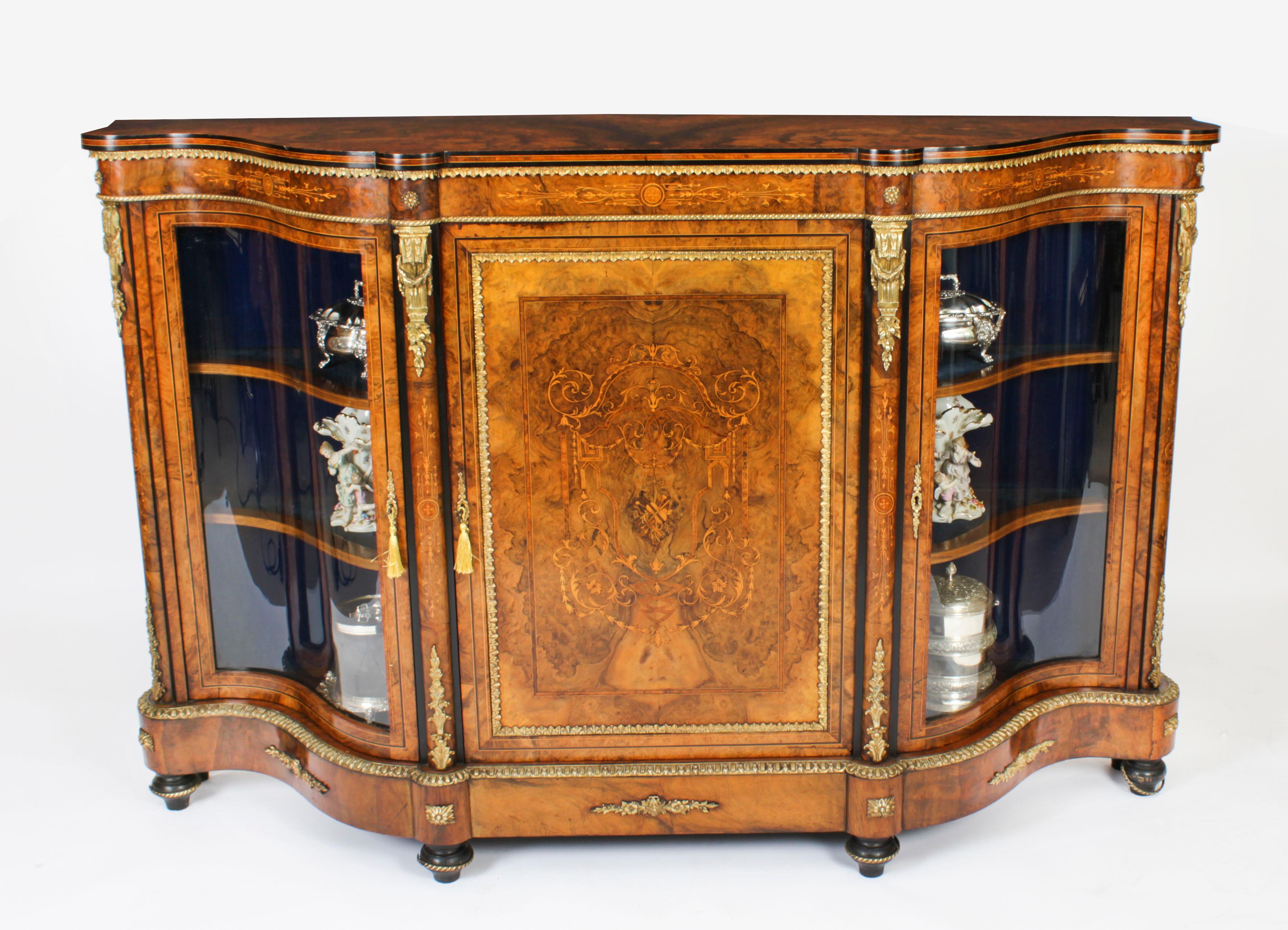 This is an exceptional quality antique Victorian ormolu mounted burr walnut, ebonised and marquetry inlaid serpentine ended credenza, circa 1860 in date.
 
The entire piece highlights the unique and truly exceptional pattern of the book matched