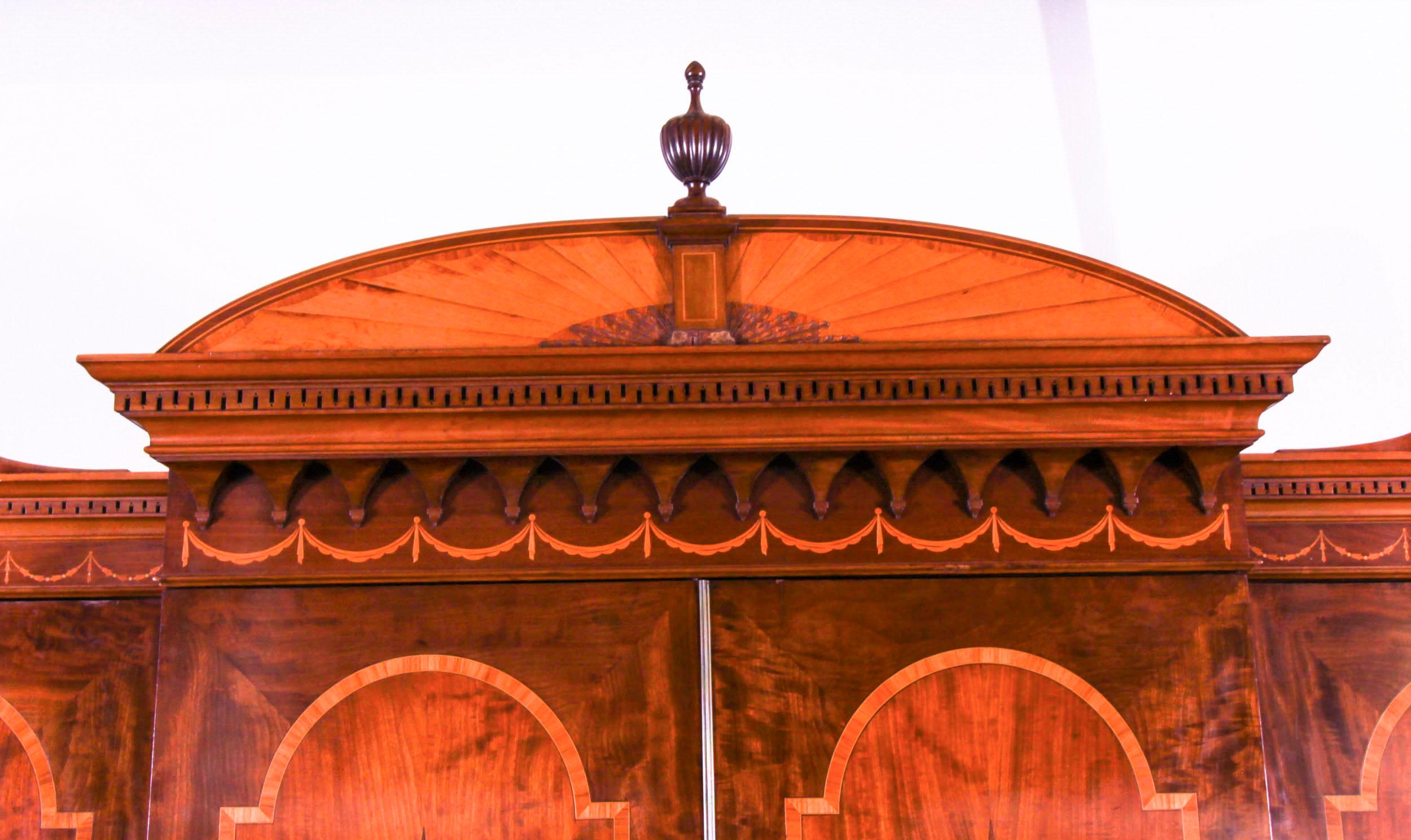 Si tratta di un imponente armadio vittoriano Sheraton Revival in mogano a fiamma, legno di raso e bosso, realizzato da Marsh Jones Cribb & Co. di Leeds e Cavendish Square di Londra, datato circa 1880.

L'armadio presenta un triplo cornicione molto