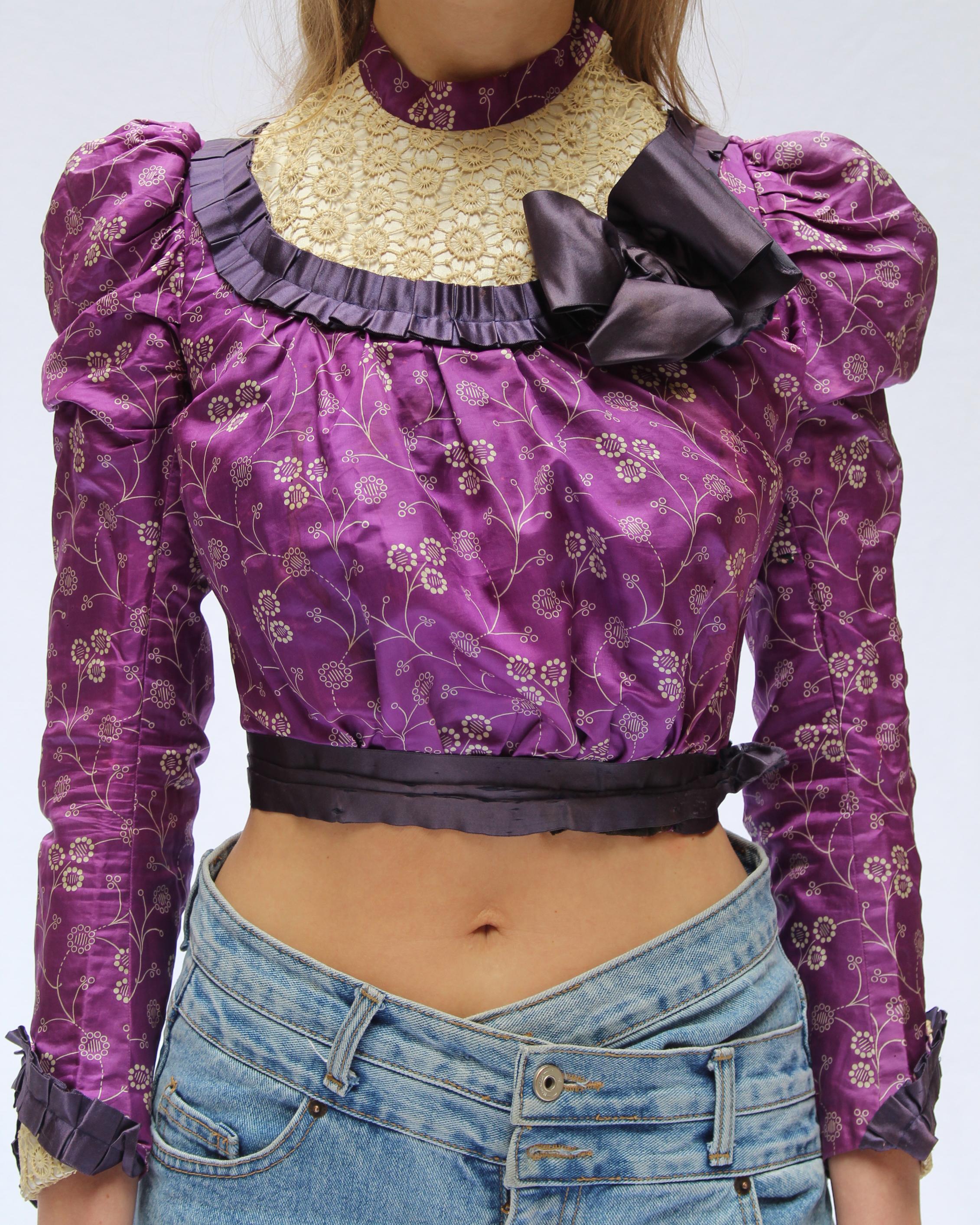 Antike viktorianische Kleidung ist selten genug zu bekommen, und diese Bluse ist ein ganz besonderes Sammlerstück. CIRCA 1890, aus wunderschöner bedruckter Seide, mit lilafarbenen Seidendetails und Häkelspitzendetails an Brust und Manschetten -