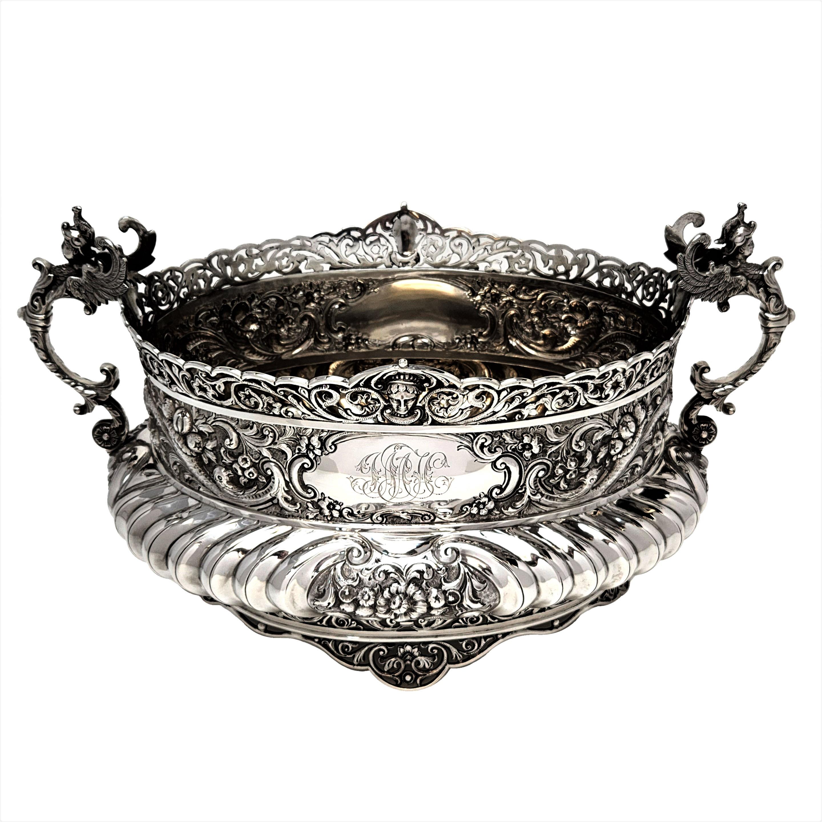 An impressive Antique Victorian solid Silver Centrepiece Bowl standing on a removable black oval plinth. The Silver Bowl has an oval shape and is decorated with ornate chased and pieced designs. The Centrepiece has two cartouches - one plain and one