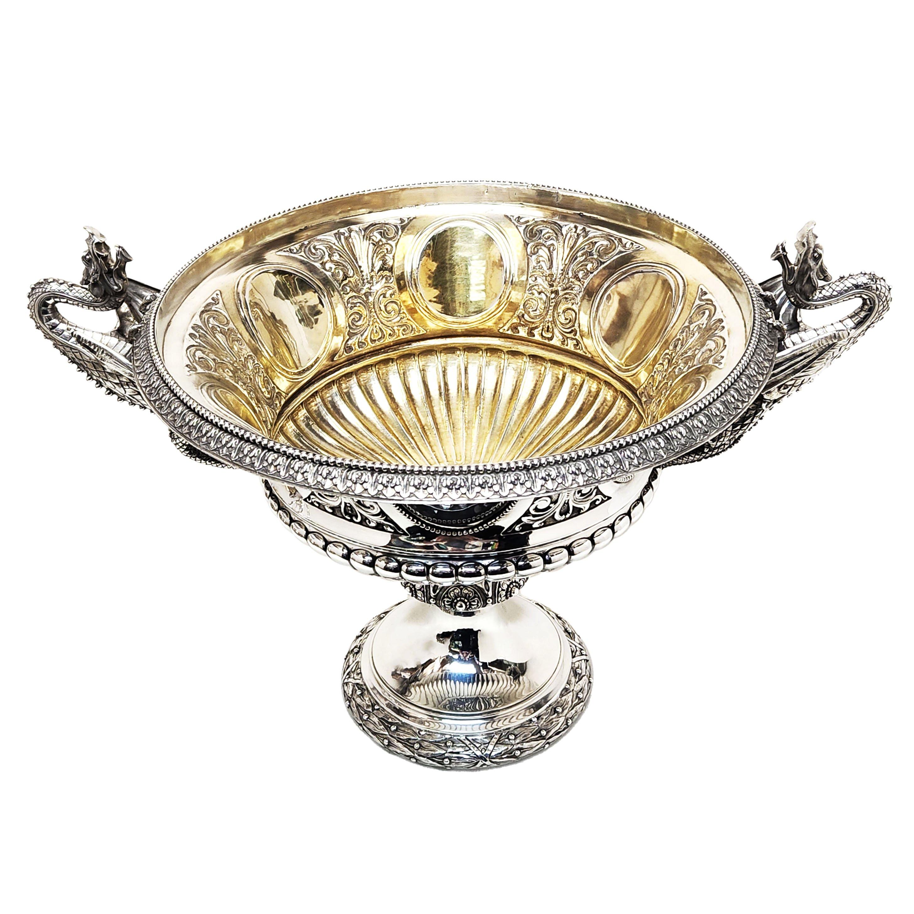 Magnifique bol à deux anses en argent de l'époque victorienne, avec des anses extrêmement impressionnantes en forme de dragons ailés. Les côtés de cette coupe ancienne sont ornés d'une série de cartouches circulaires polis entourés de rinceaux