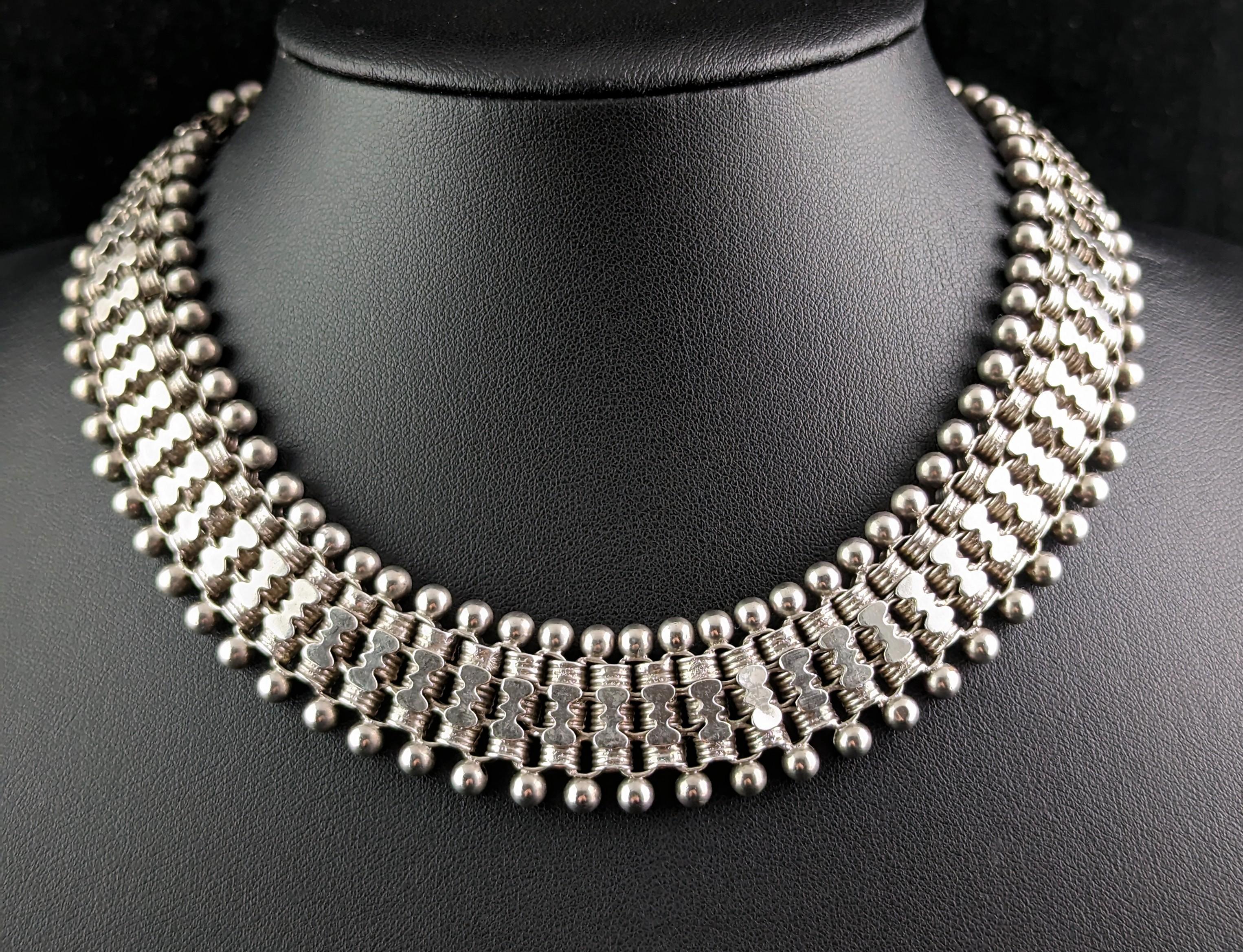 This is a most elaborate antique, Victorian era sterling silver collar necklace.

This is one of the most extravagant examples I have seen and there is so much detailing on this piece you are not sure where to look first.

It has three rows of