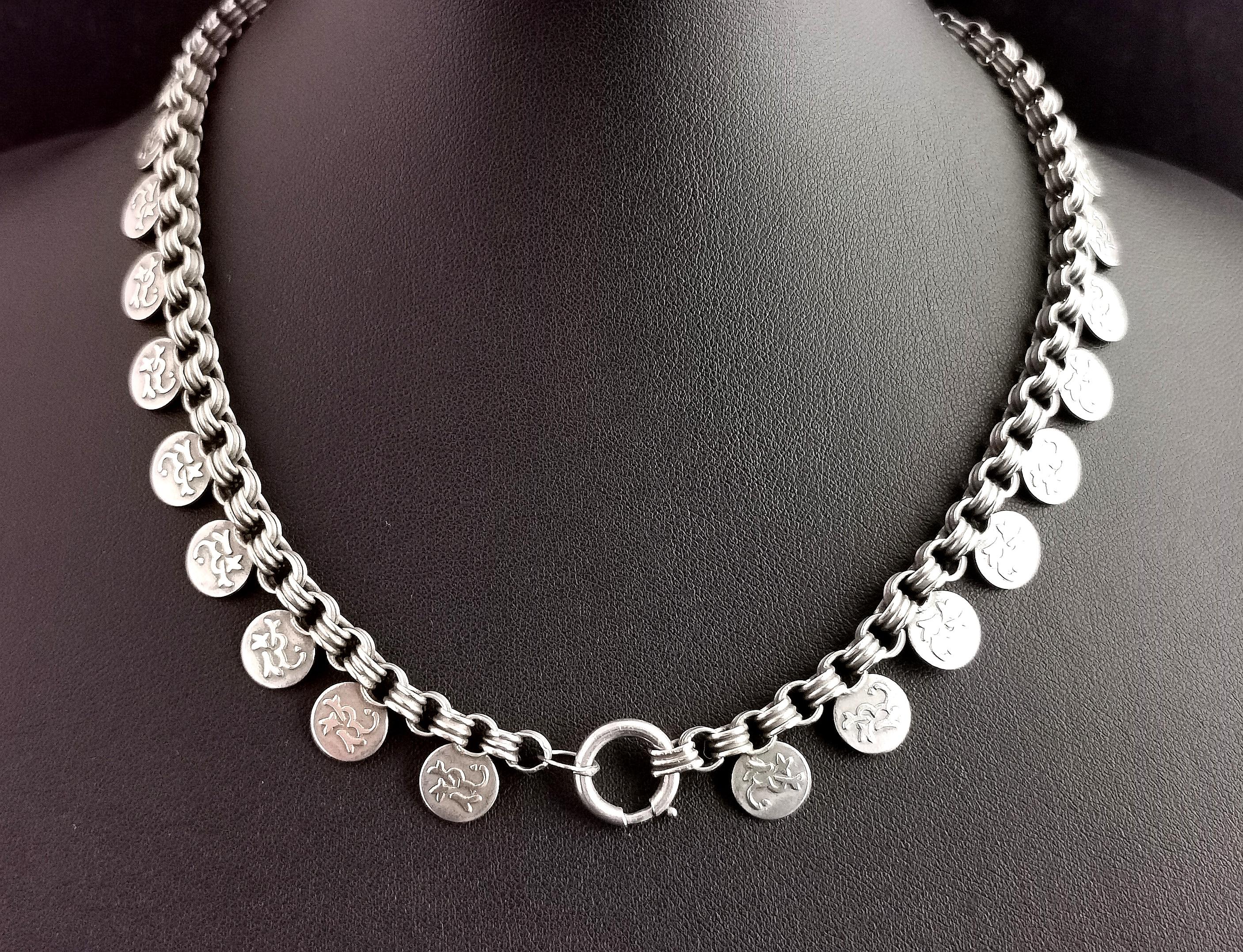 A gorgeous antique Victorian silver collar necklace.

This attractive Aesthetic era chain is made up from chunky double rolo links with a faux coin link Fringe in the Assyrian revival style.

A staple piece of Victorian jewellery and as wearable in