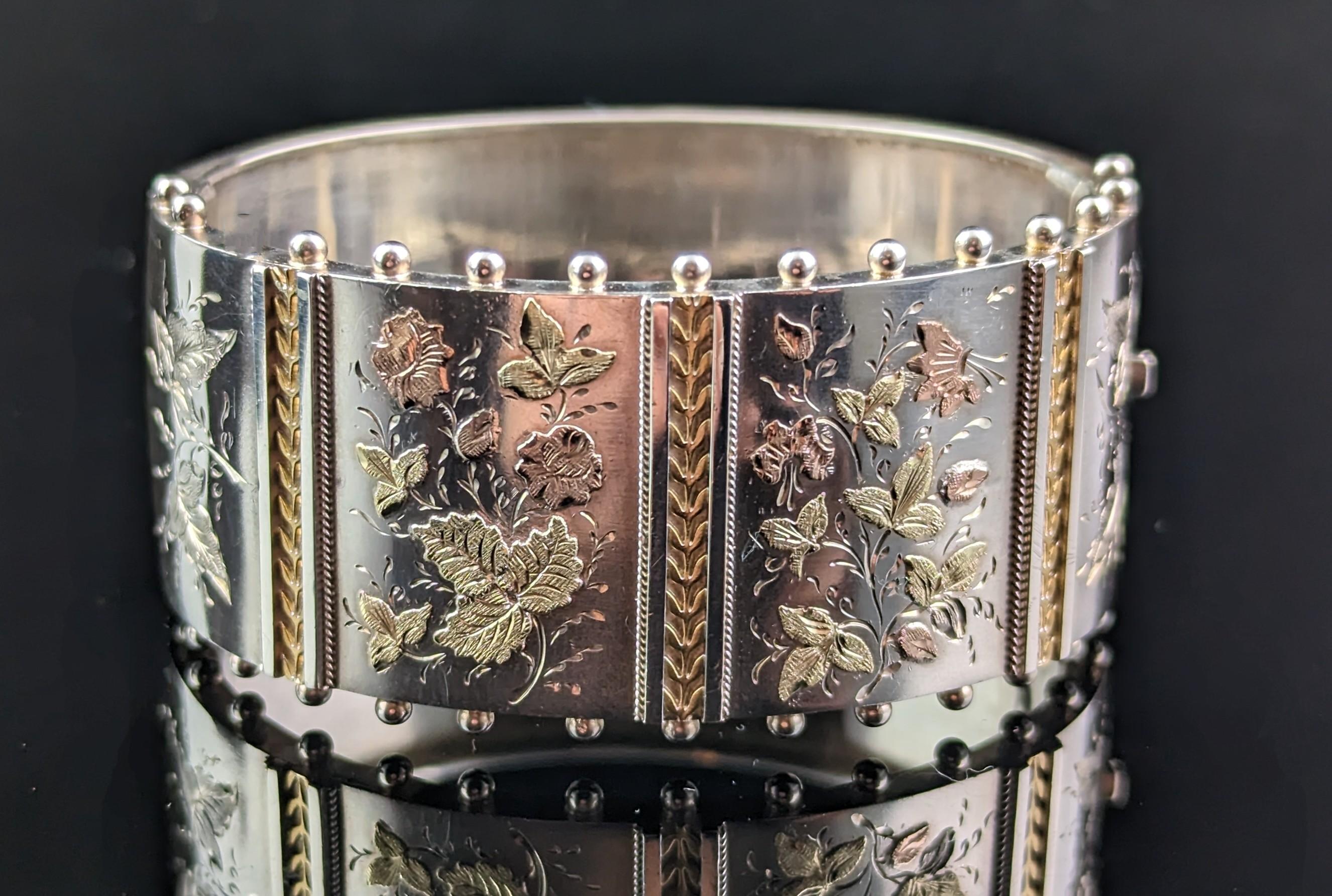 You can't help but fall in love with this gorgeous antique, Victorian Aesthetic, sterling silver chunky cuff bangle.

Repousse detailing picked out in yellow and rose gold with a floral design and engraved in the aesthetic manner with a smooth