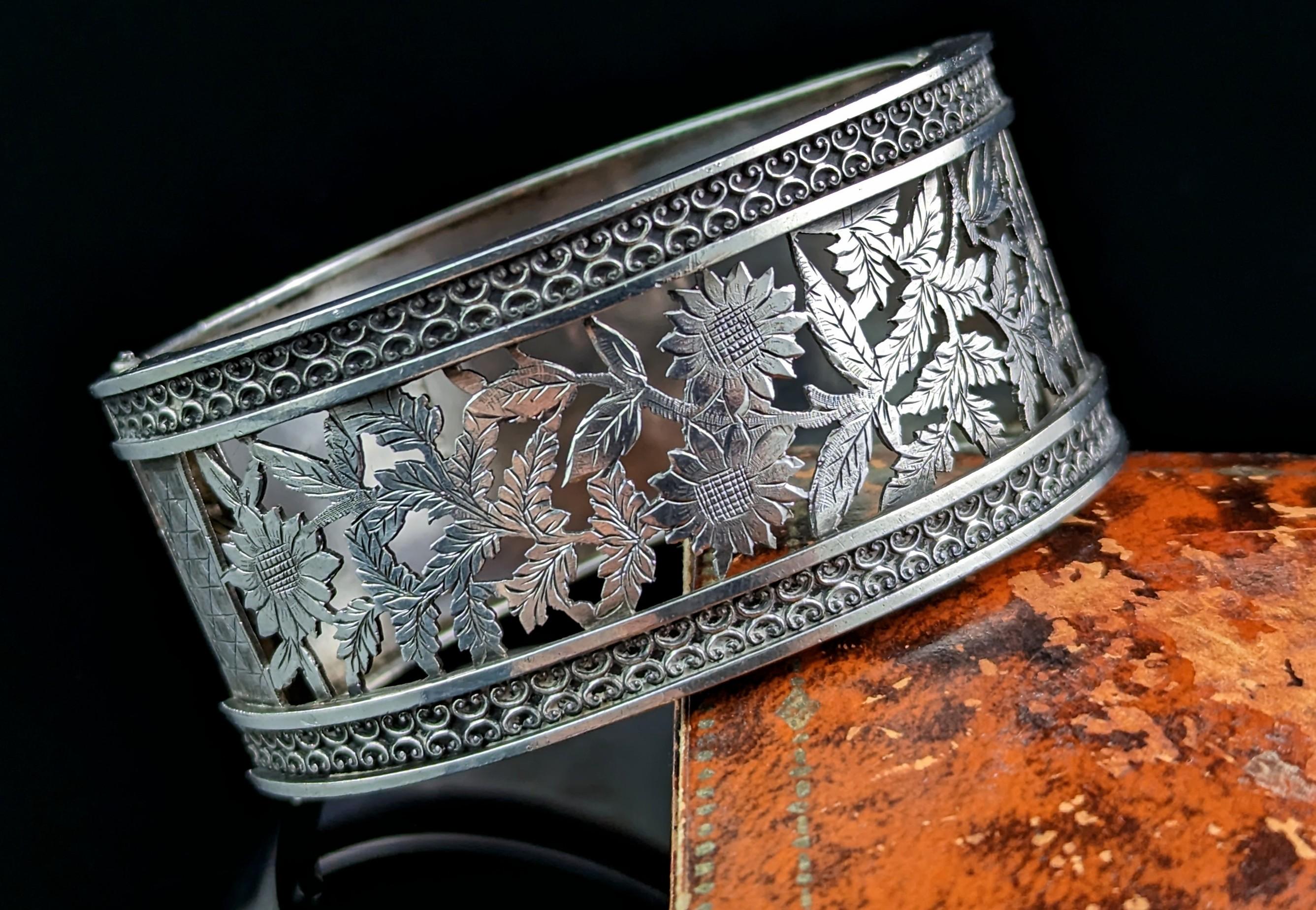 You can't help but fall in love with this gorgeous antique, Victorian era, sterling silver chunky cuff bangle.

A rare design the front half of the bangle has a pierced cut out design of florals with engraved highlights, the reverse is a smooth