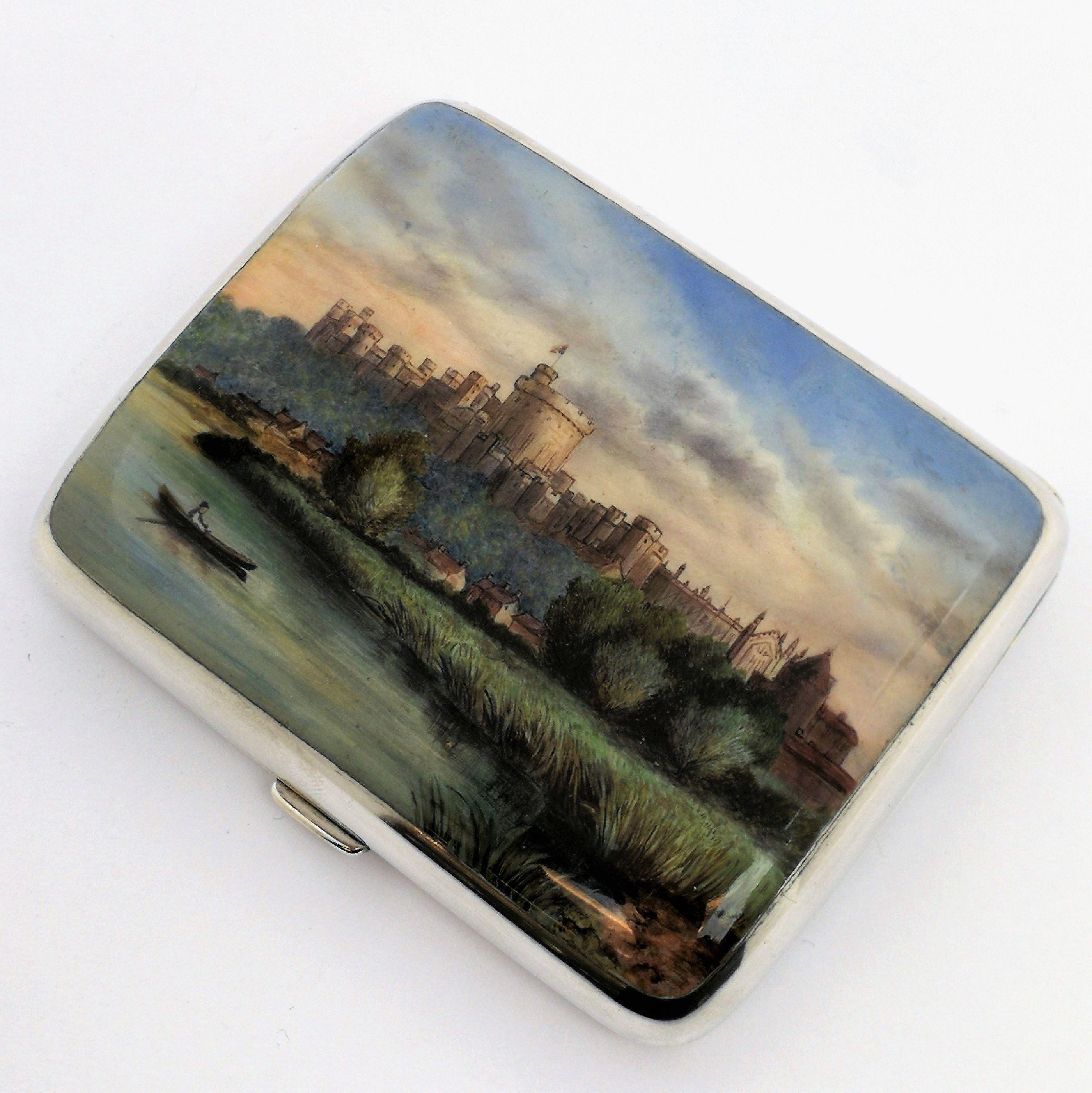 A gorgeous antique Victorian solid silver cigarette case featuring an enamelled image on the front cover showing a view of Windsor castle from the river. The image is created in a rich palette of colour and exquisite detail. The case has a plain