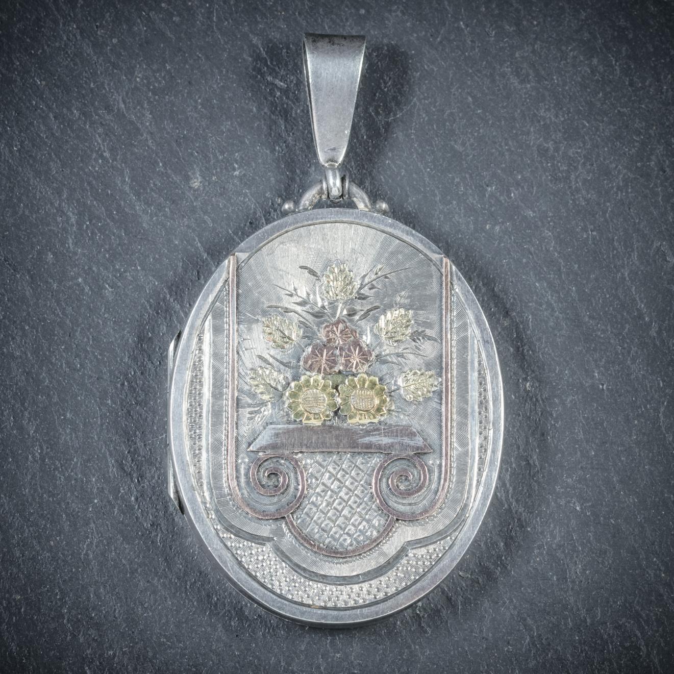 This beautiful antique Victorian Sterling Silver locket displays a beautiful engraved bouquet of flowers and leaves on the front which are set in 18ct Yellow Gold and Rose Gold

The Locket opens and closes securely and fitted with Silver rims